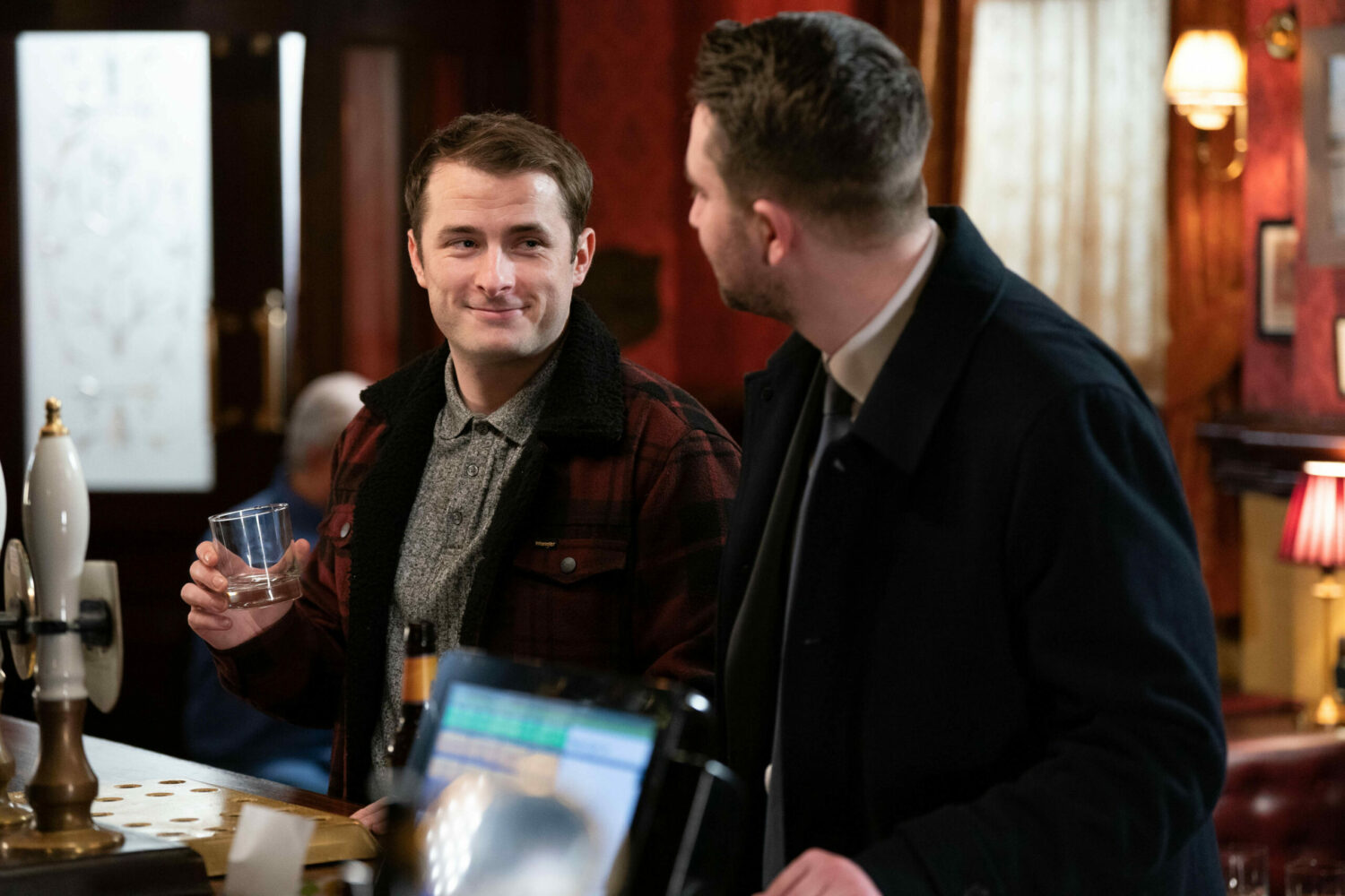 Ben Mitchell smiles at husband Callum Highway in The Queen Vic over a drink