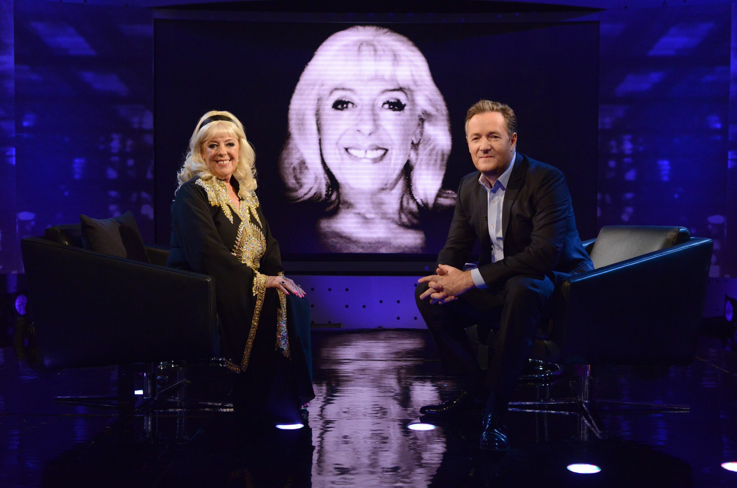 Julie Goodyear and Piers Morgan pose on set for Life Stories on ITV