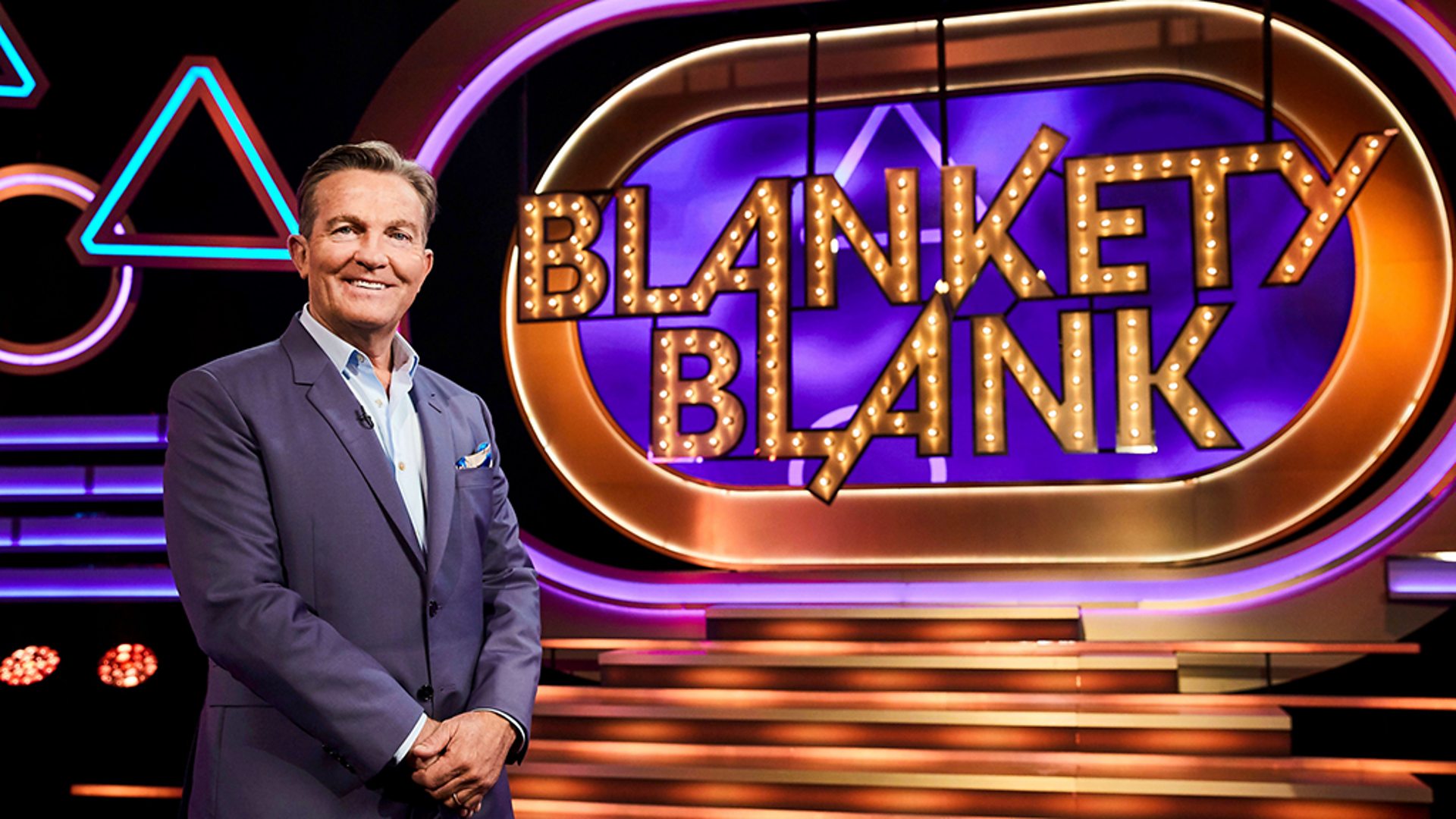 Bradley Walsh smiles in front of the Blankety Blank sign