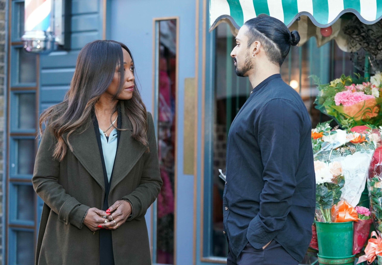 Denise and Ravi are talking outside the flower stall