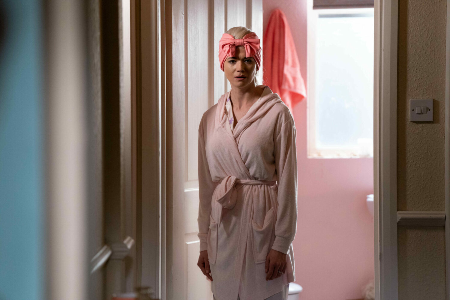 Lola is standing in the door way in her dressing gown