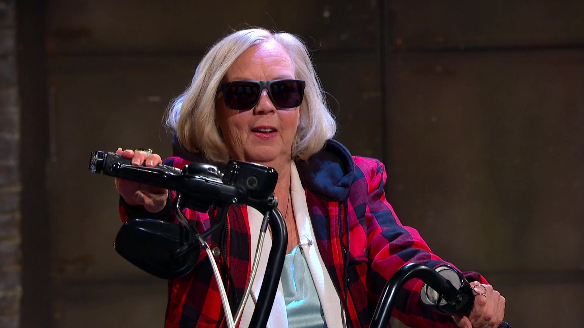 Deborah Meaden mounts a motorbike wearing sunglasses on Dragons' Den