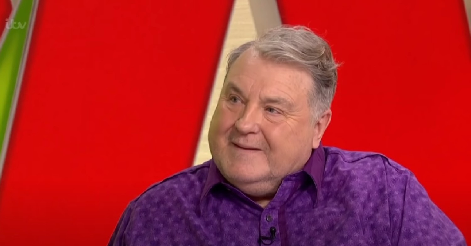 Russell Grant smiling in purple shirt on Loose Women