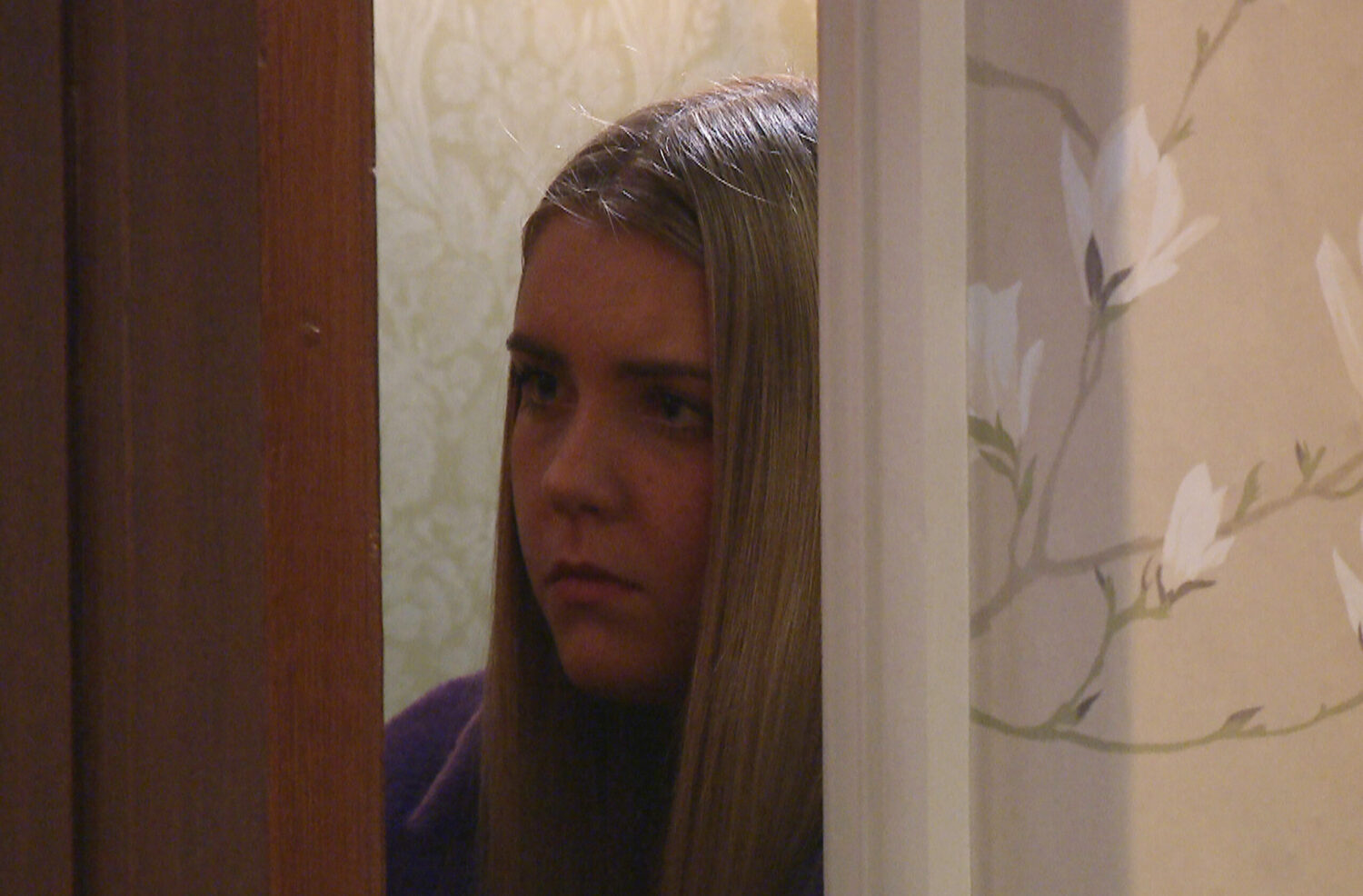 Cathy Hope eavesdrops behind a door looking anxious