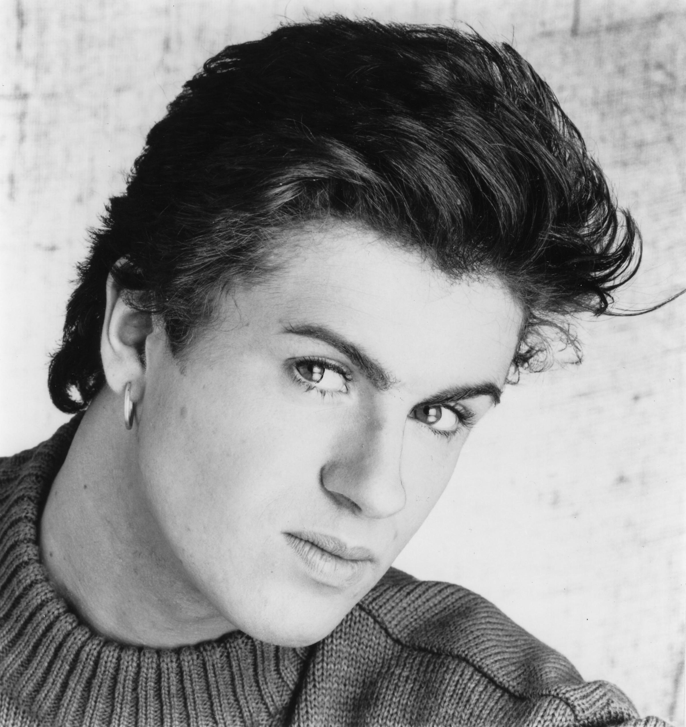 George Michael smiles in black and white photo