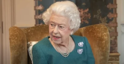 The Queen wearing green looking to the side