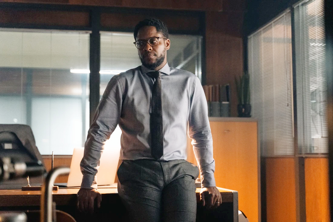 Samuel leans on a desk in Young Wallander