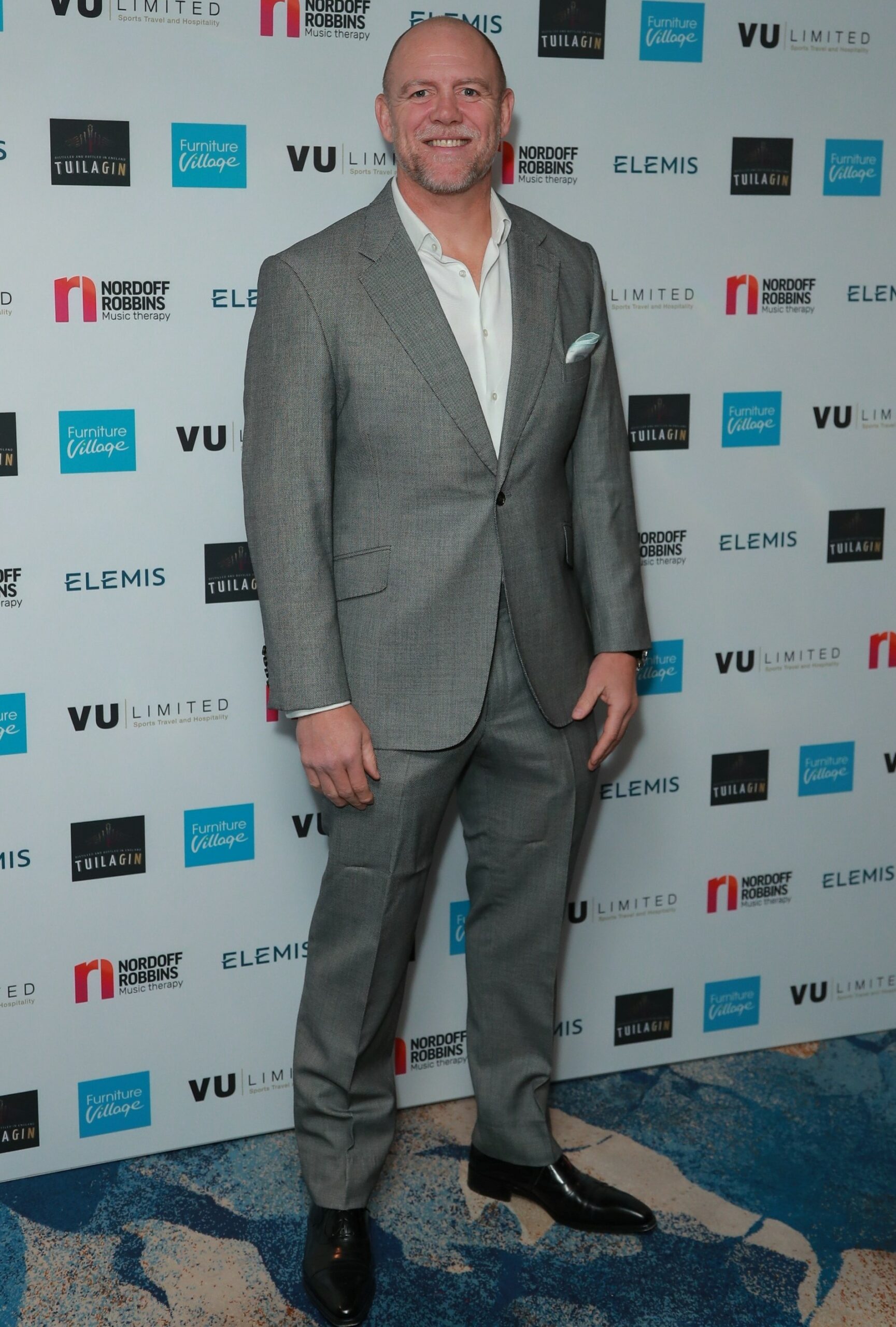 Mike Tindall smiling in grey suit at event