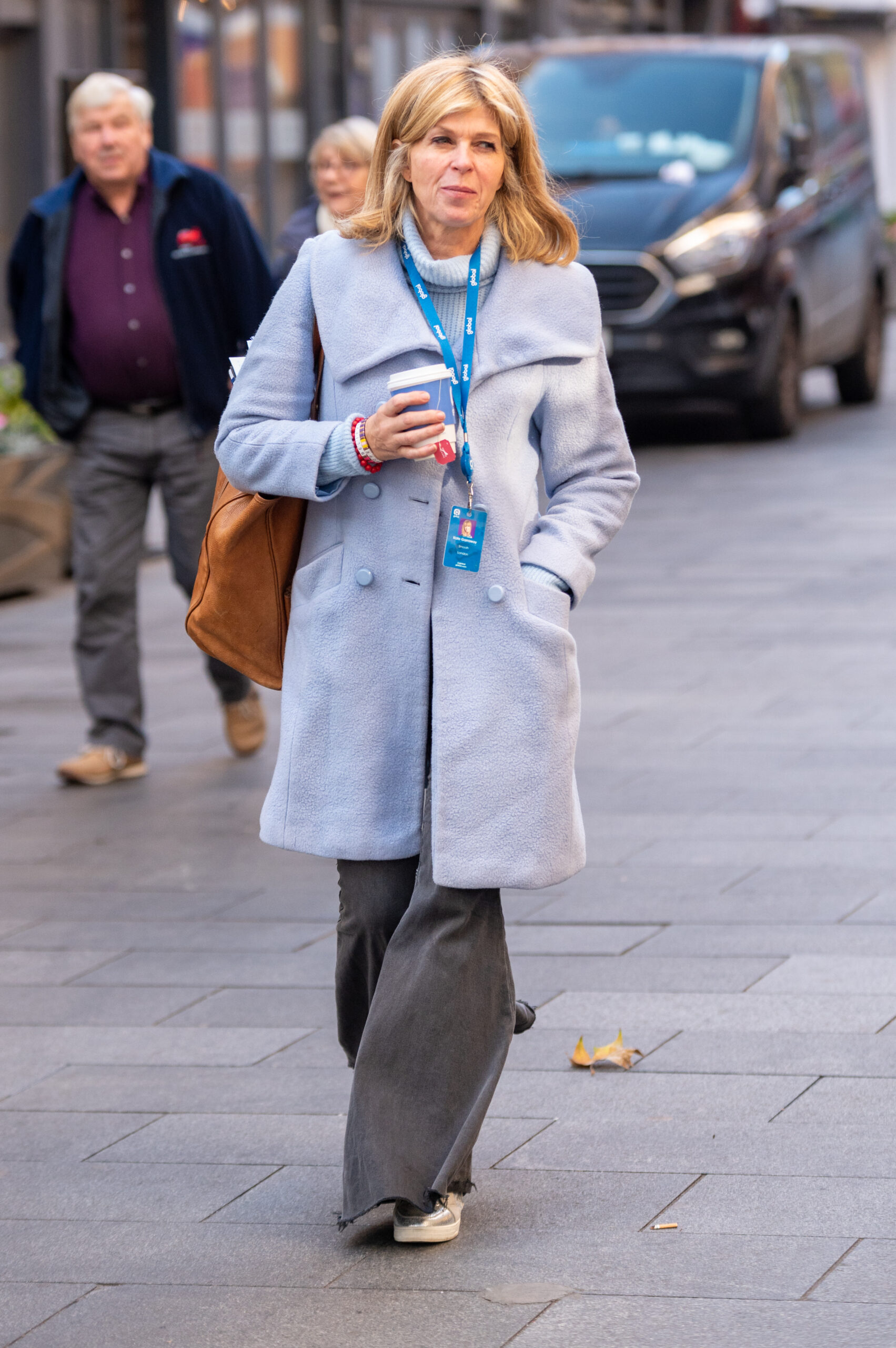 Derek Draper's wife Kate Garraway wearing a blue coat and walking