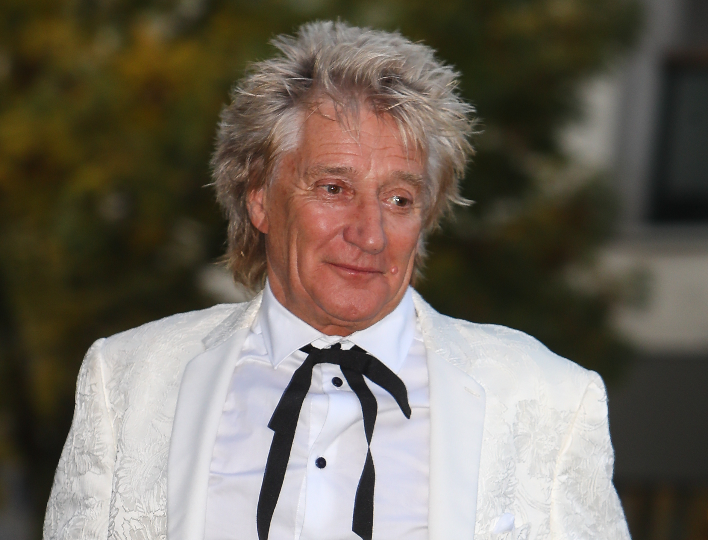 Rod Stewart smiling wearing white