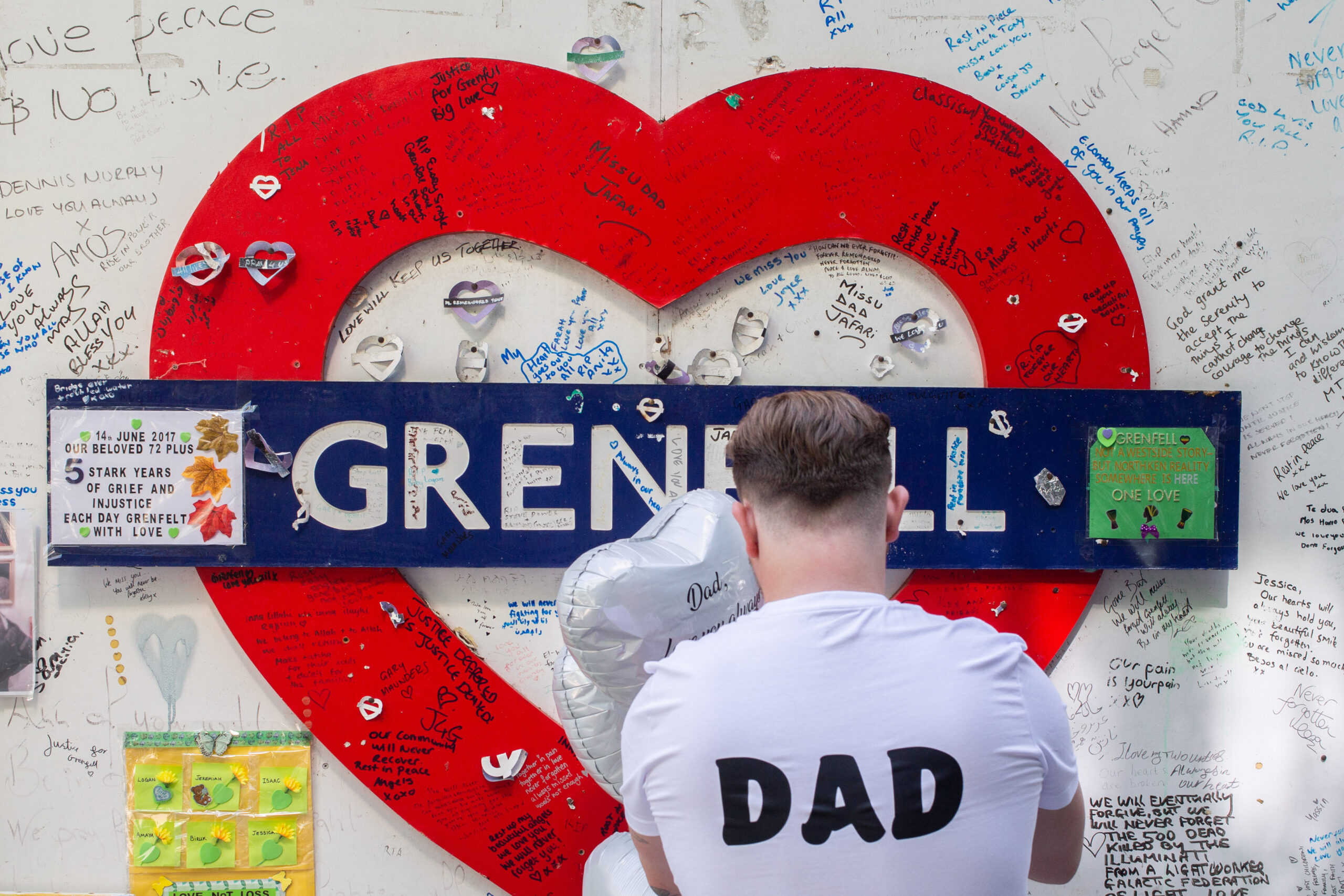 A grieving dad pays tribute at Grenfell Fire sign