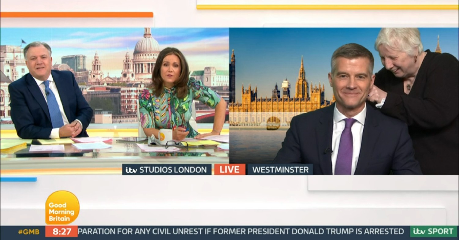 Ed Balls and Susanna Reid speaking to Mark Harper - who is having his microphone checked by a crew member - on GMB today