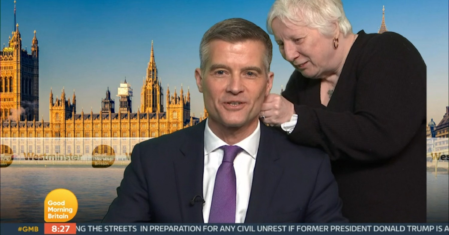 Crew member helping Mark Harper with his mic on GMB today