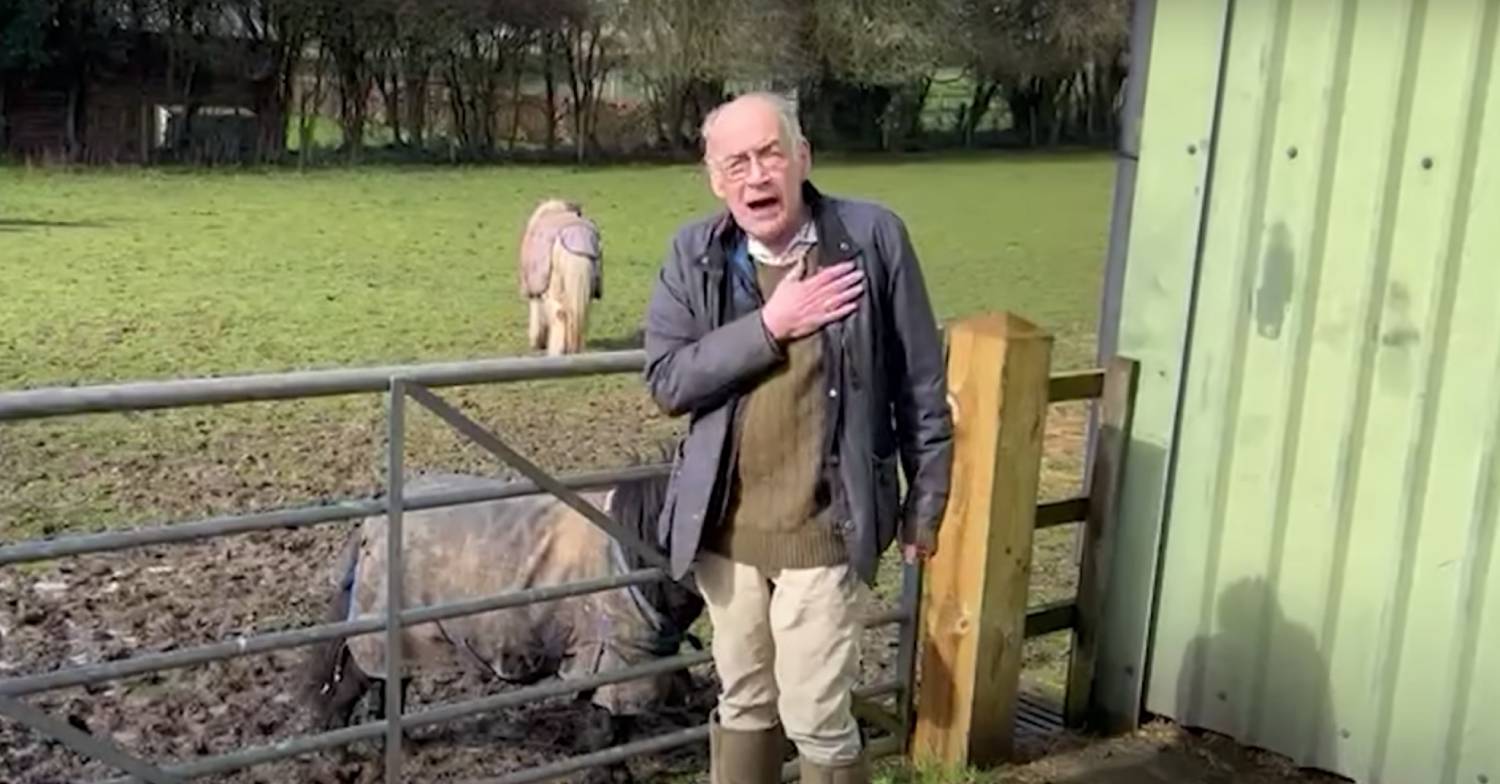 Alastair Stewart speaking to the camera with his hand on his chest on GB News