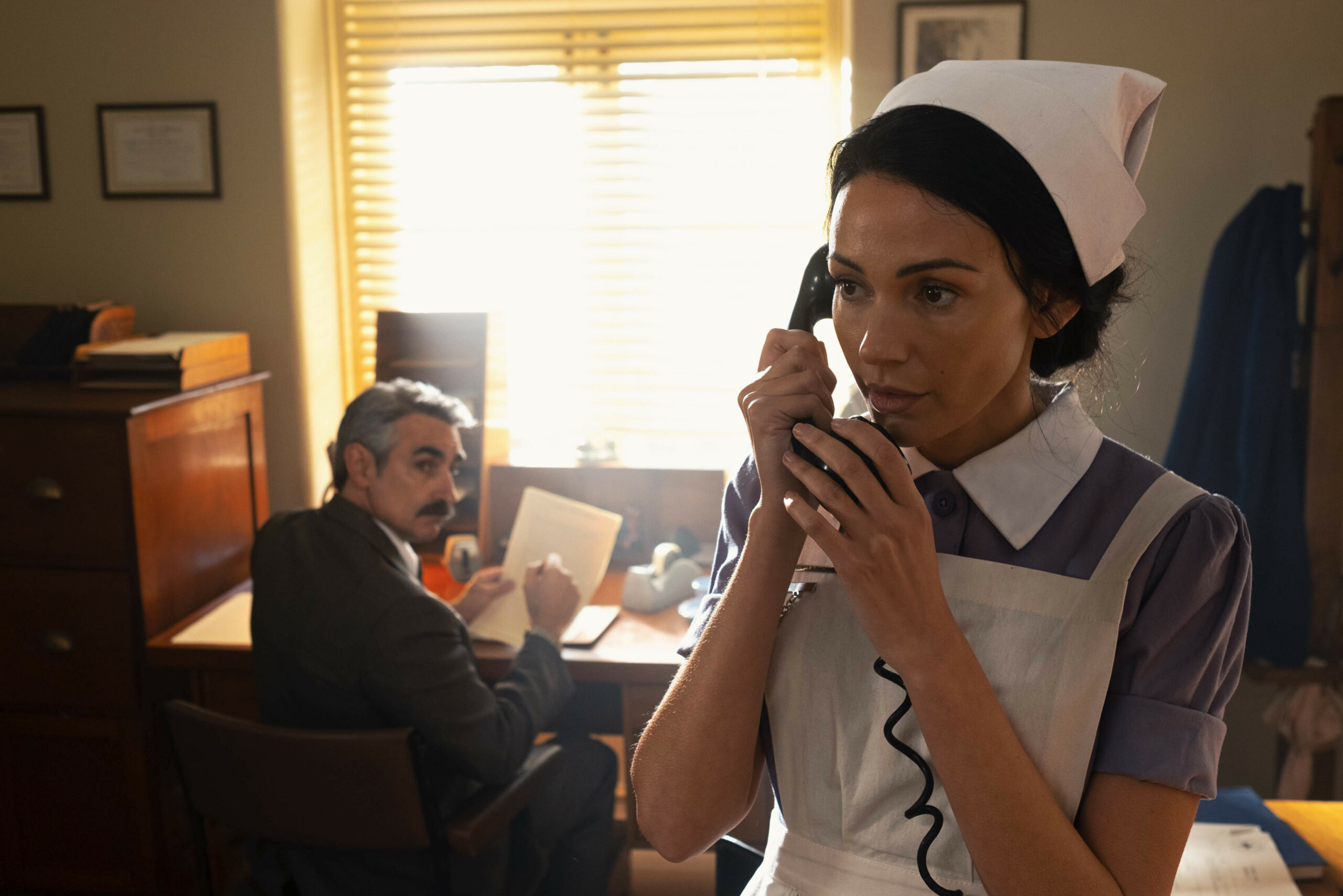 Nurse Kate speaks on the phone in Ten Pound Poms