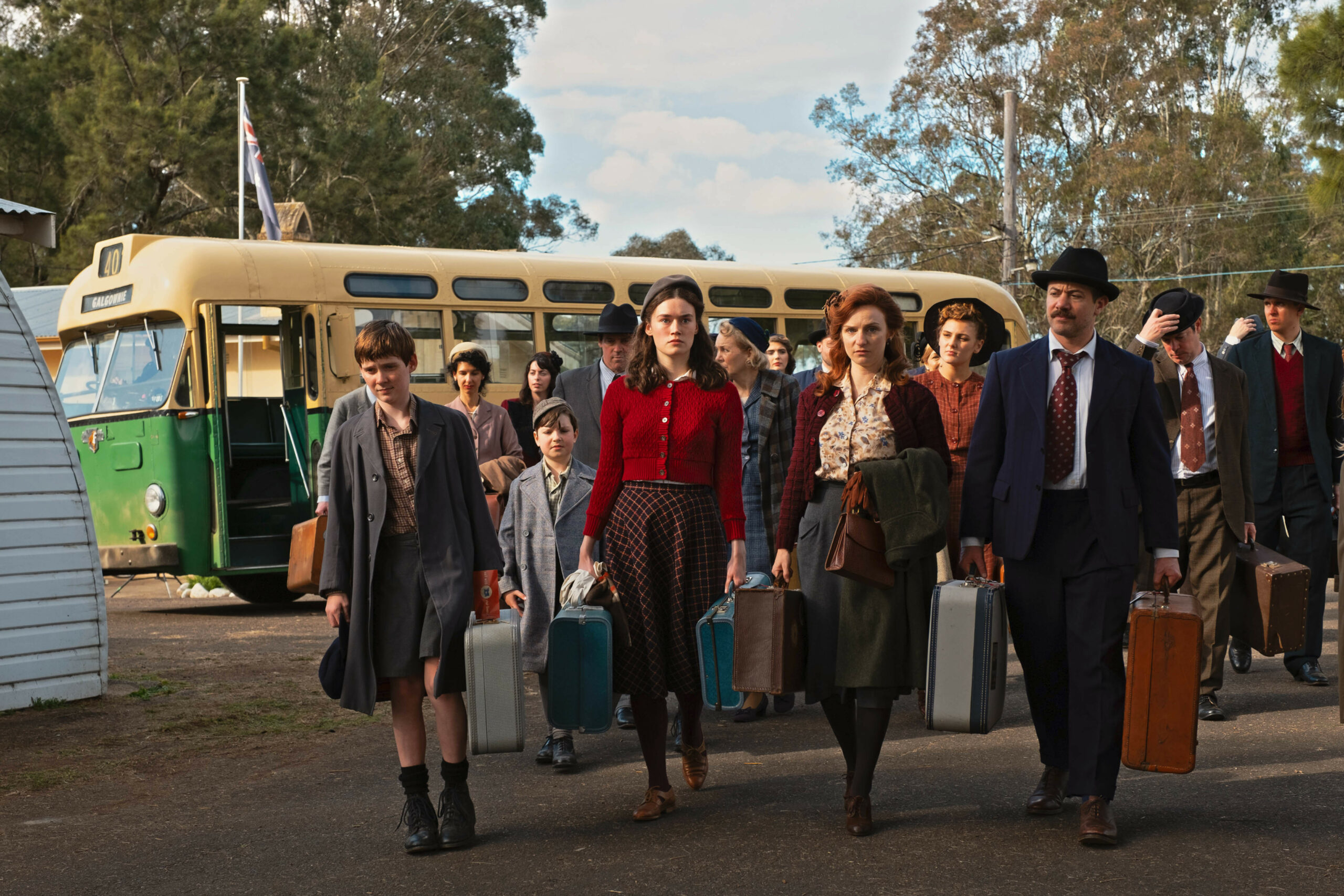 The cast of Ten Pound Poms stand outside the migrant hostel