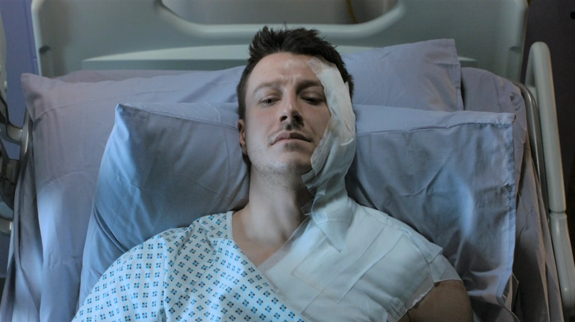 Ryan Connor lies in a hospital bed in Corrie bandaged up after his acid attack