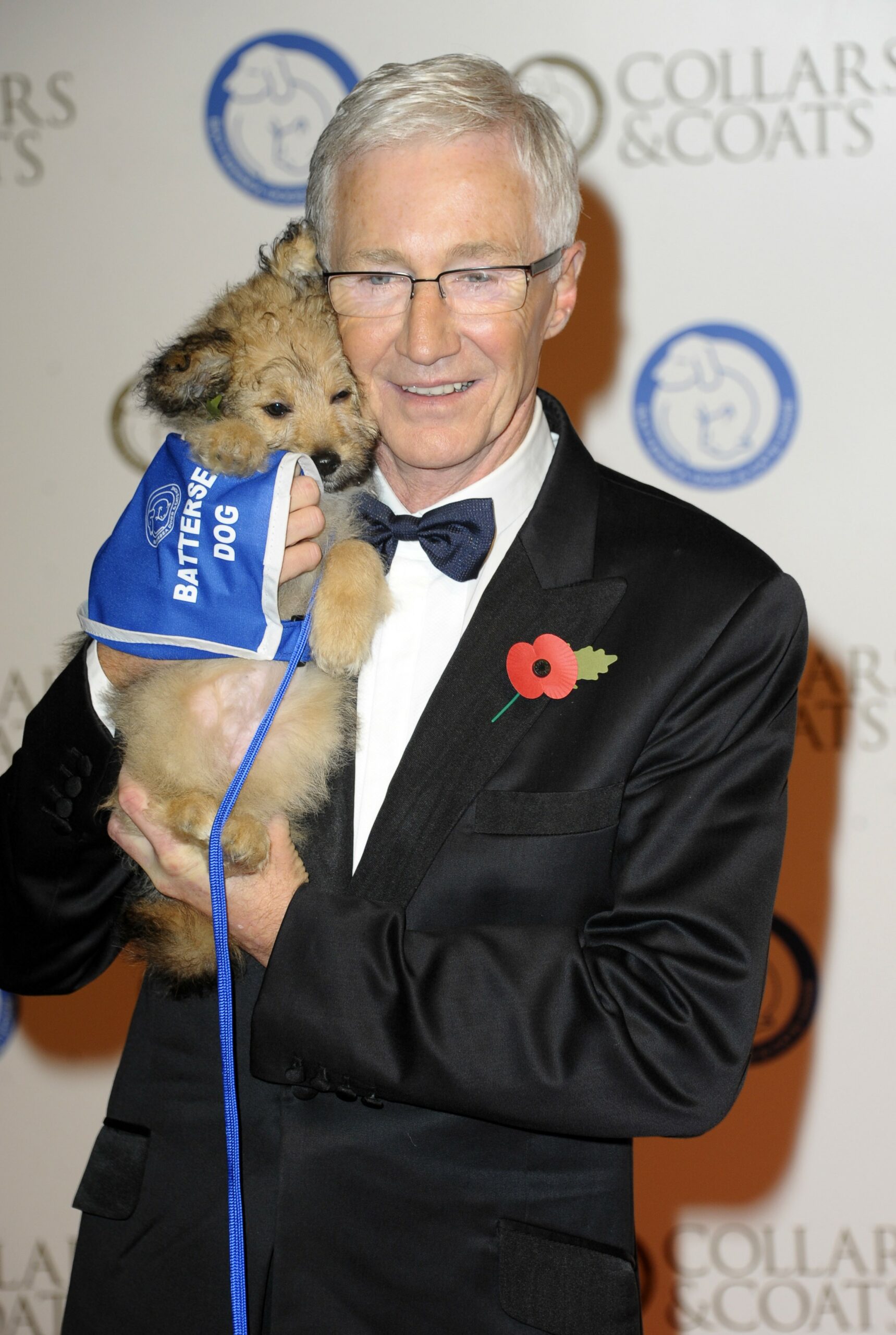 Paul O'Grady cuddling a dog at event
