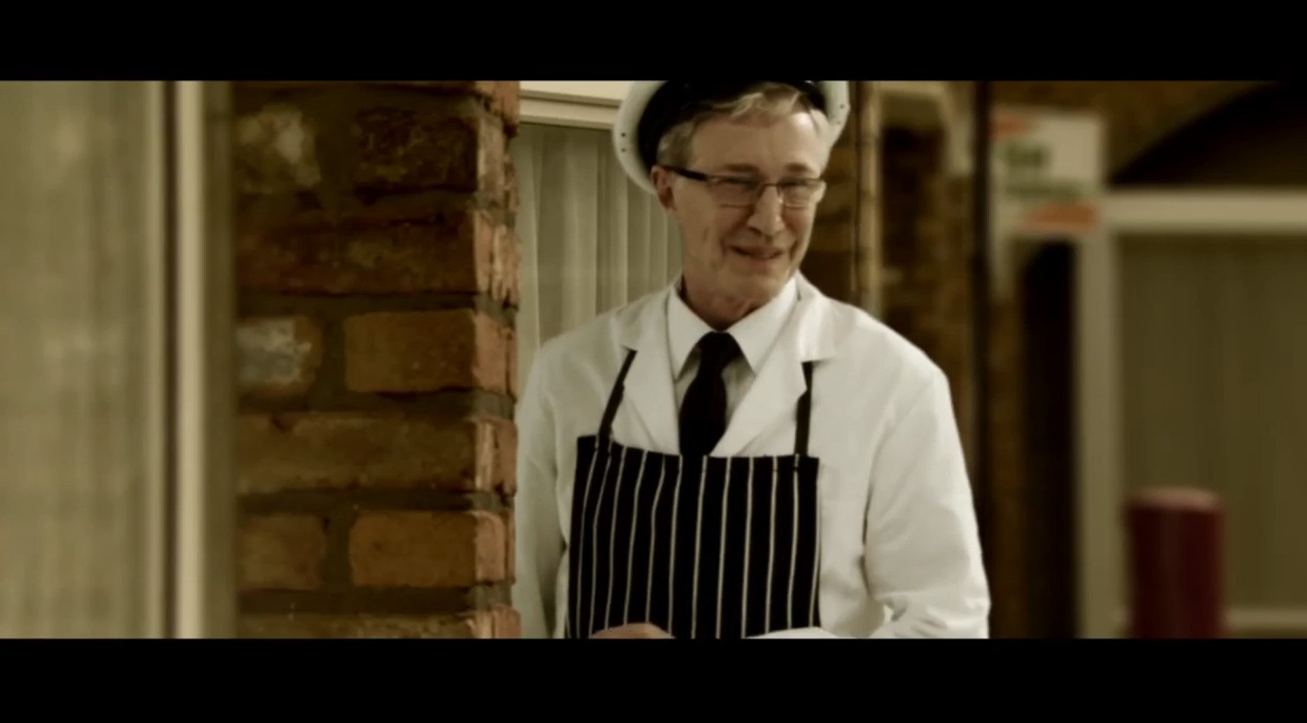 Paul O'Grady in the Street of Dreams musical as a milkman smiling