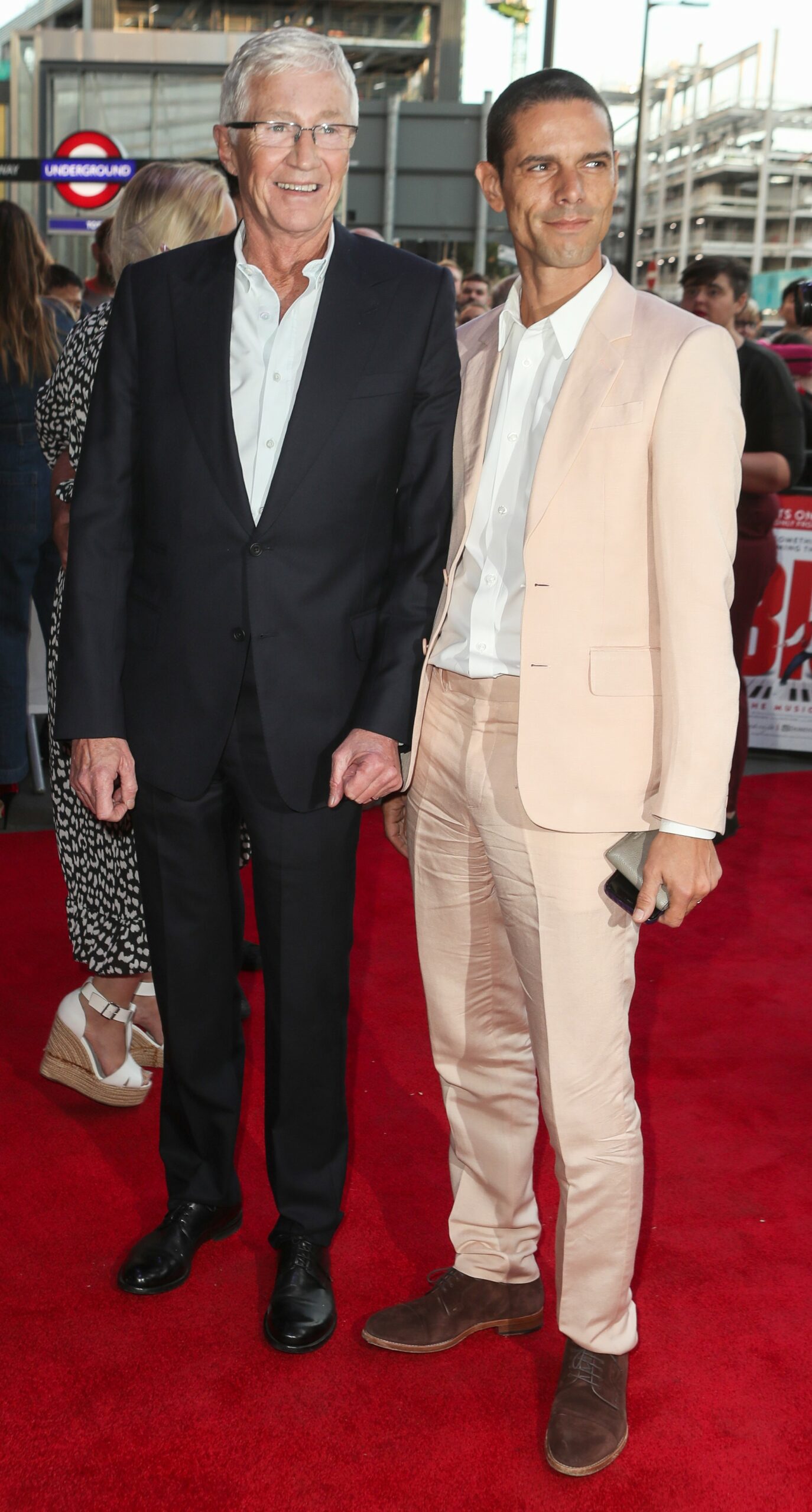 Paul O'Grady smiling with husband Andre at event