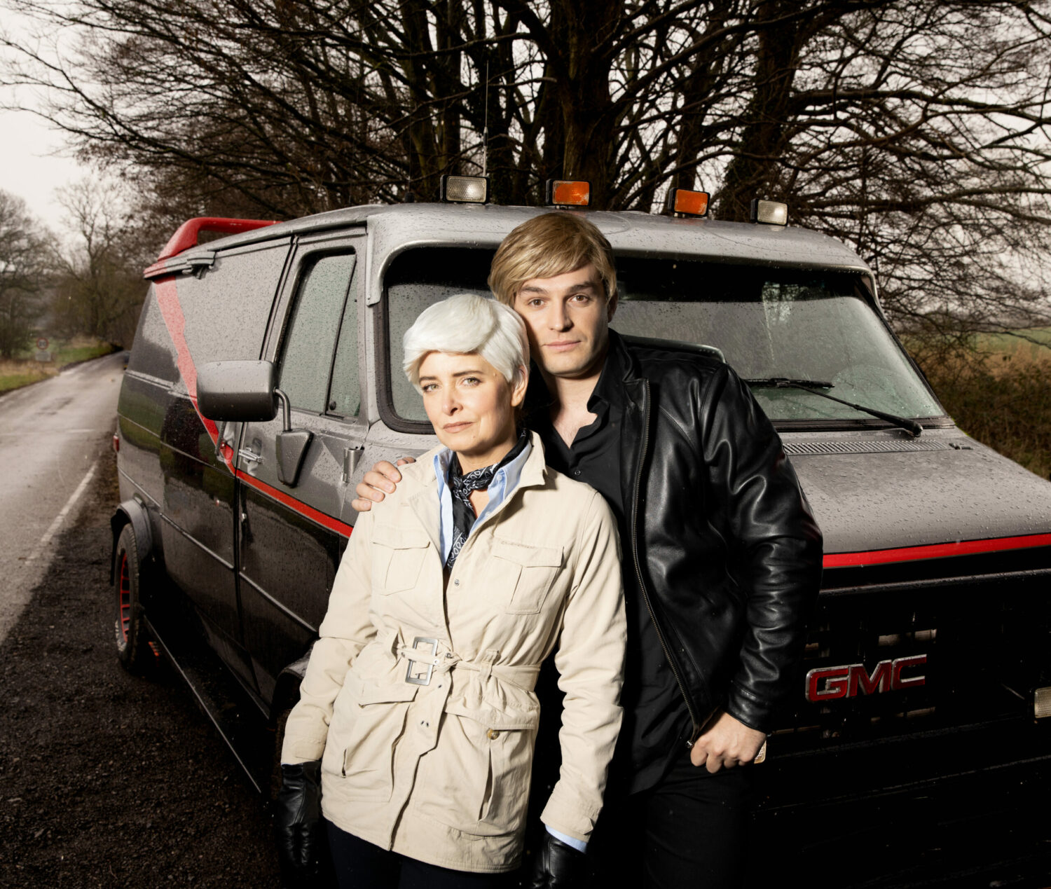 Charity and Mack are in fancy dress next to a van