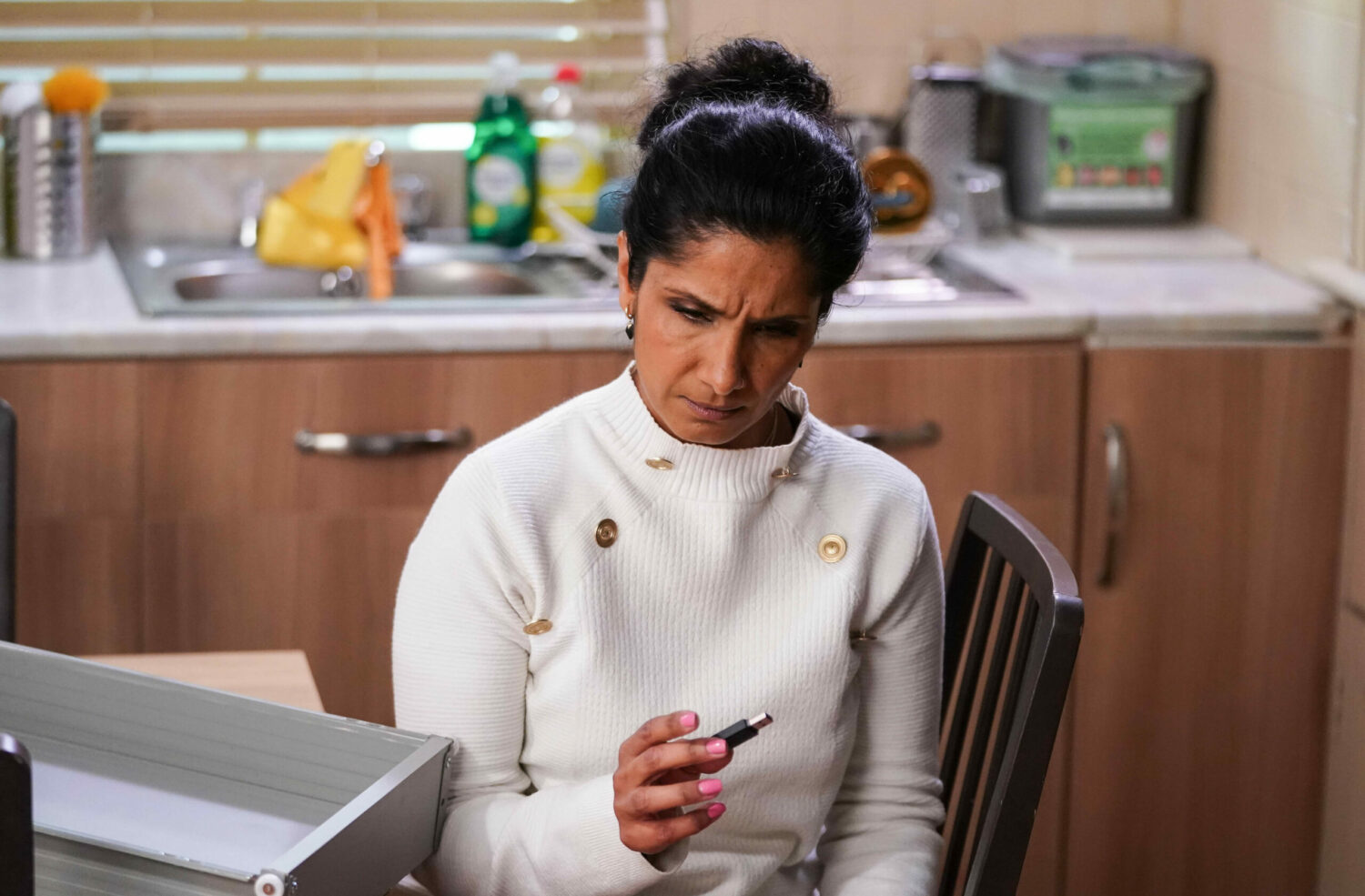 EastEnders' Suki is holding a memory stick whilst looking puzzled