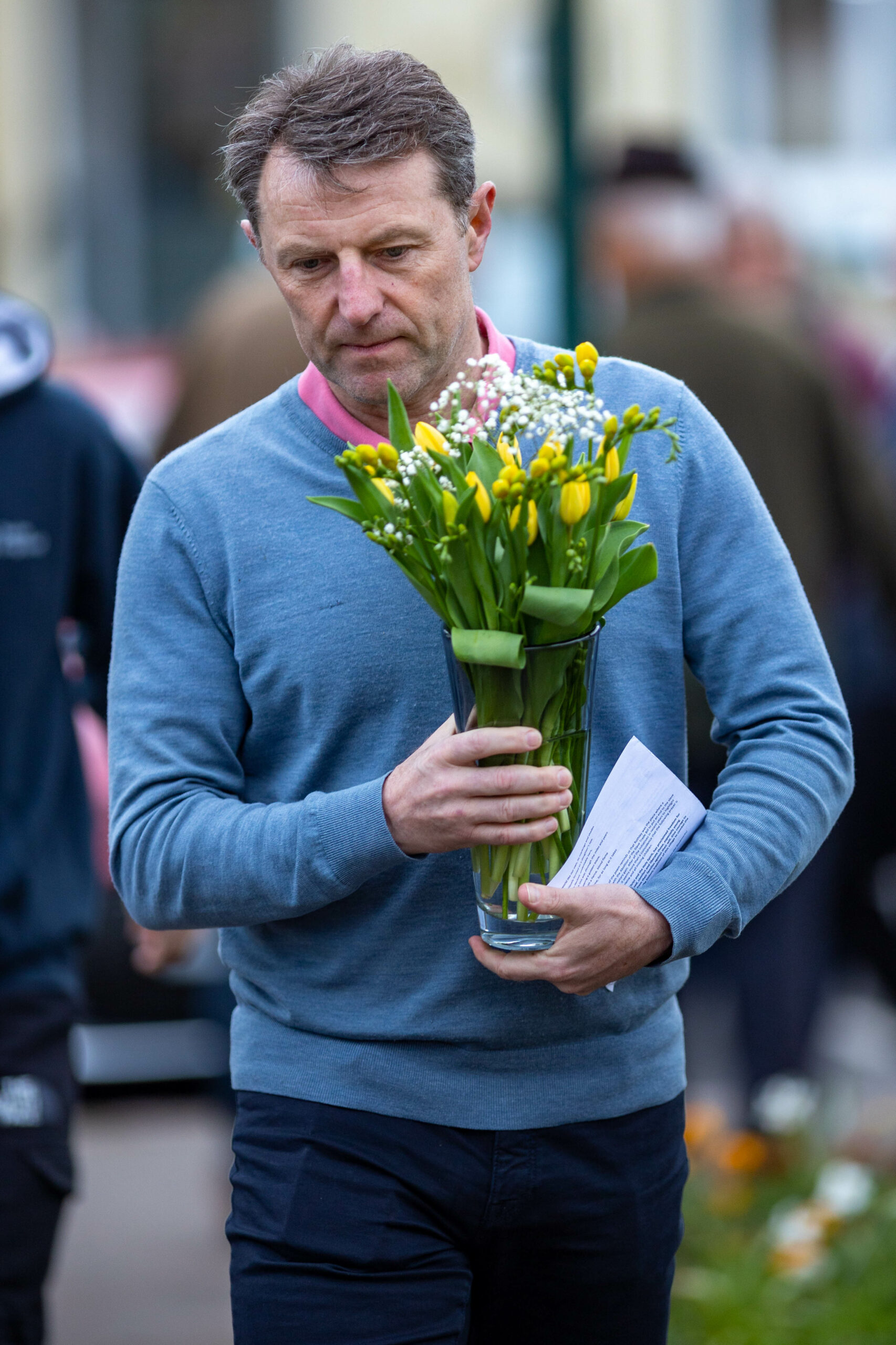 Gerry McCann holding a vase of yellow flowers