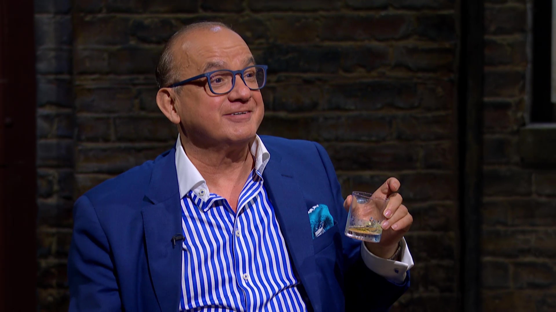 Touker Suleyman smiles with whiskey glass on Dragons Den