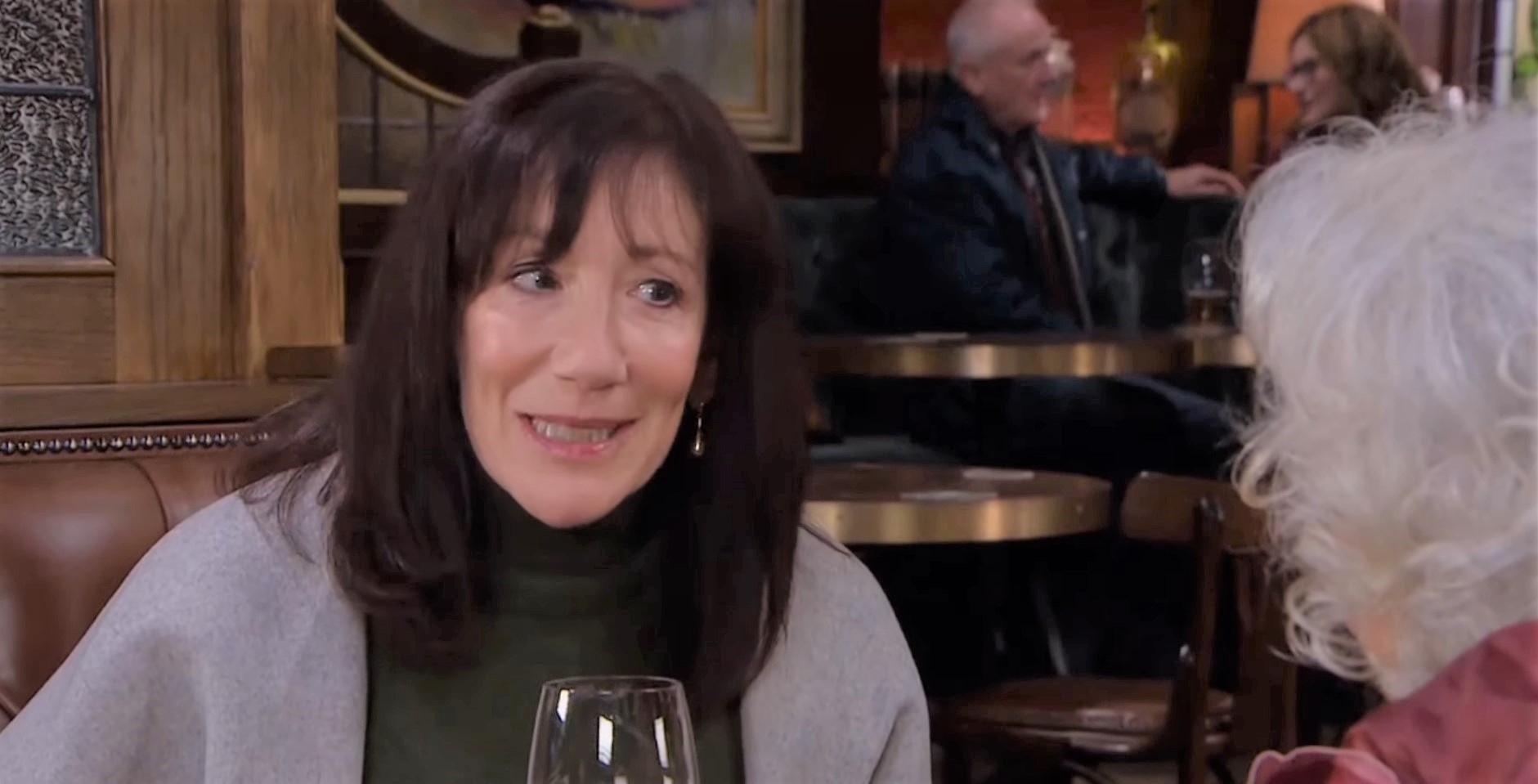 Emmerdale's Faye smiles over a glass of wine with Mary