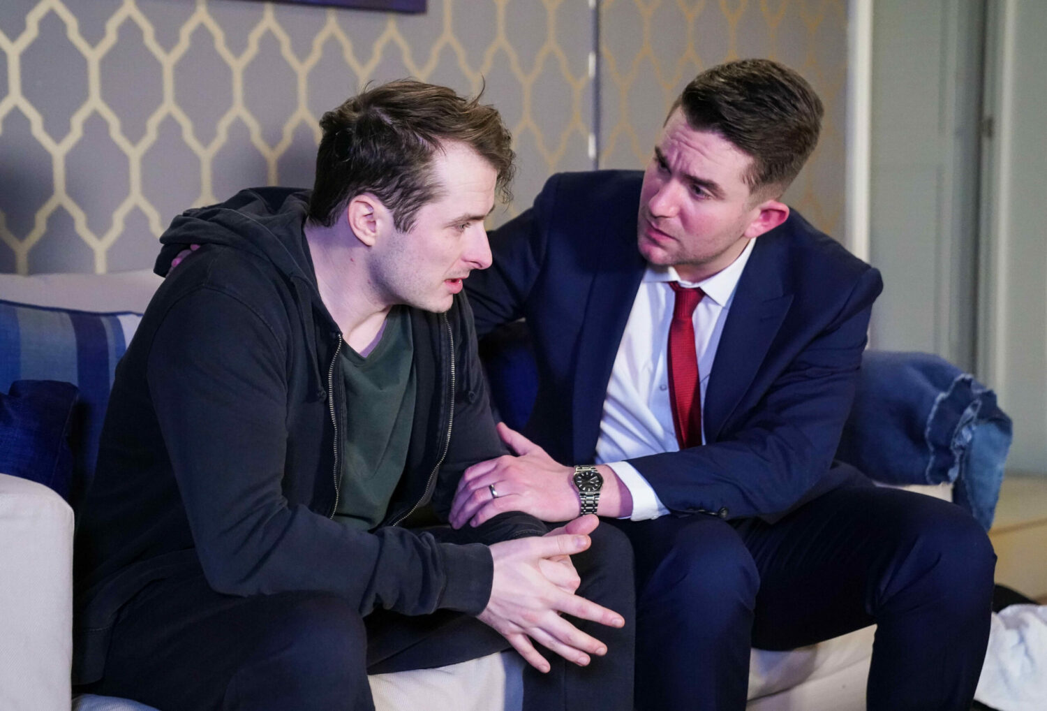 EastEnders' Callum has his hand on Ben's arm as he attempts to support him whilst sitting on the sofa