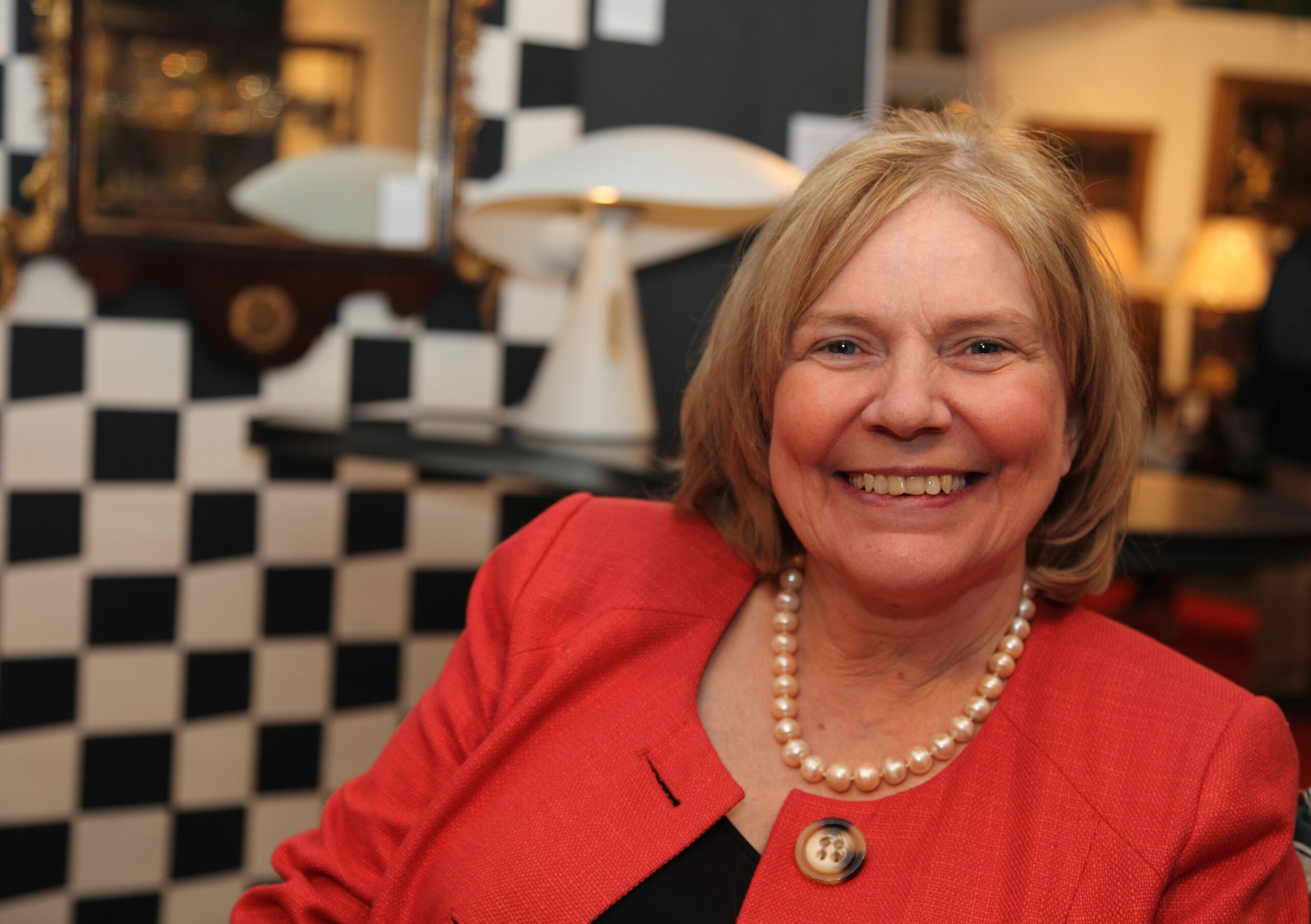Antiques Roadshow star Judith Miller smiling in red jacket