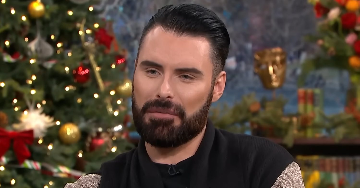 Rylan Clark looking with Christmas tree behind him on This Morning
