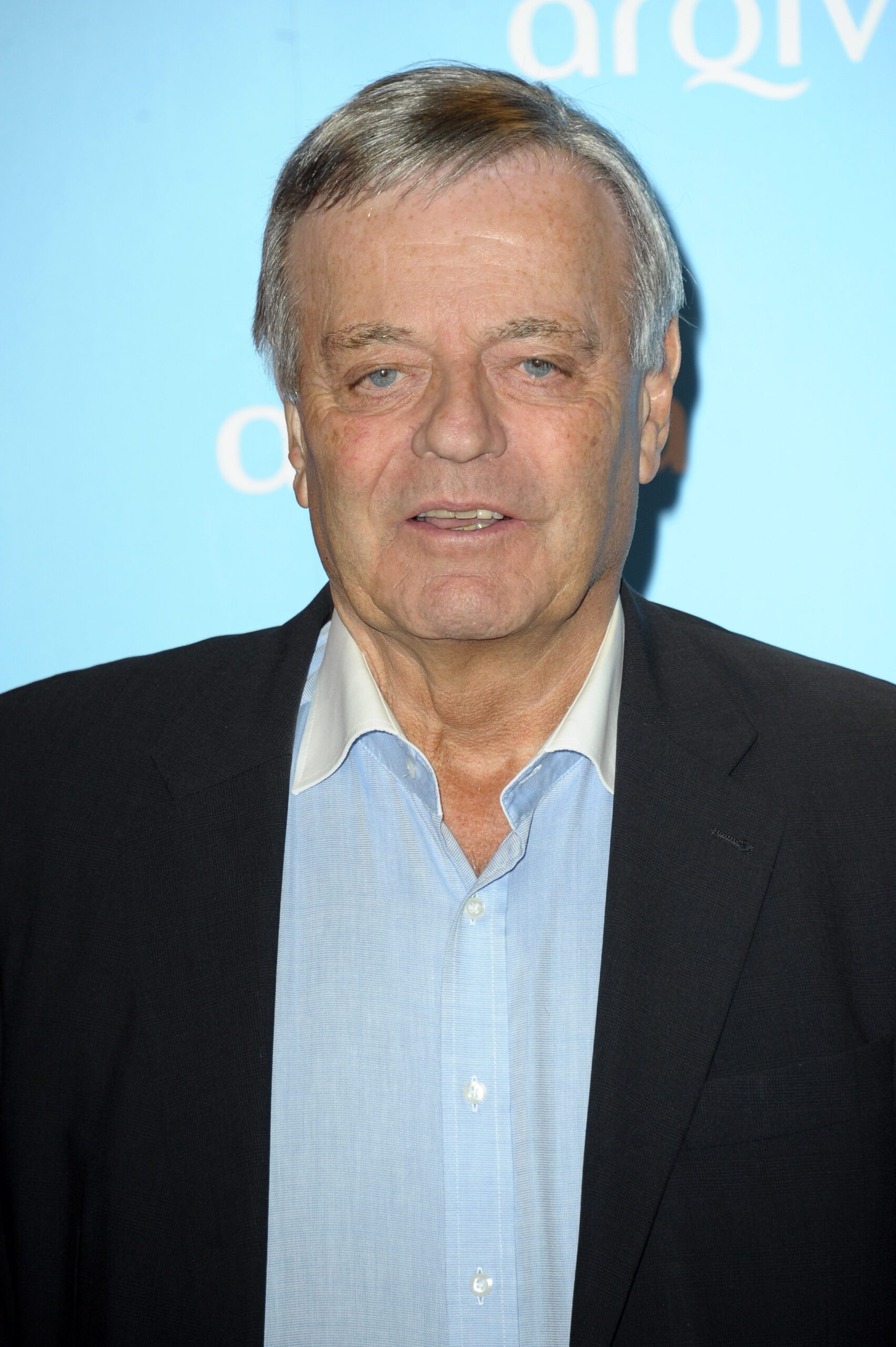 Tony Blackburn smiles slightly on the red carpet