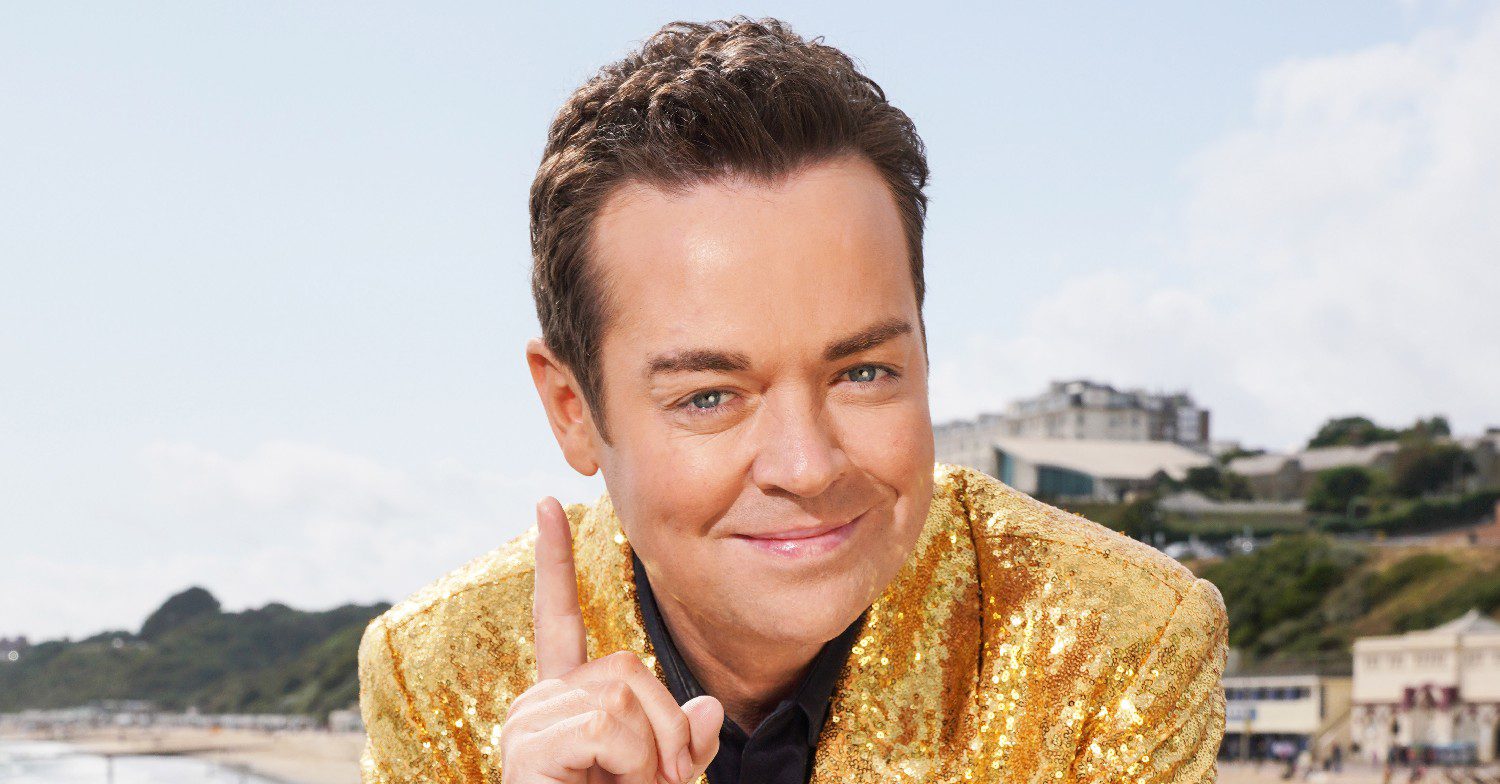 In For A Penny star Stephen Mulhern smiles with his finger pointed up