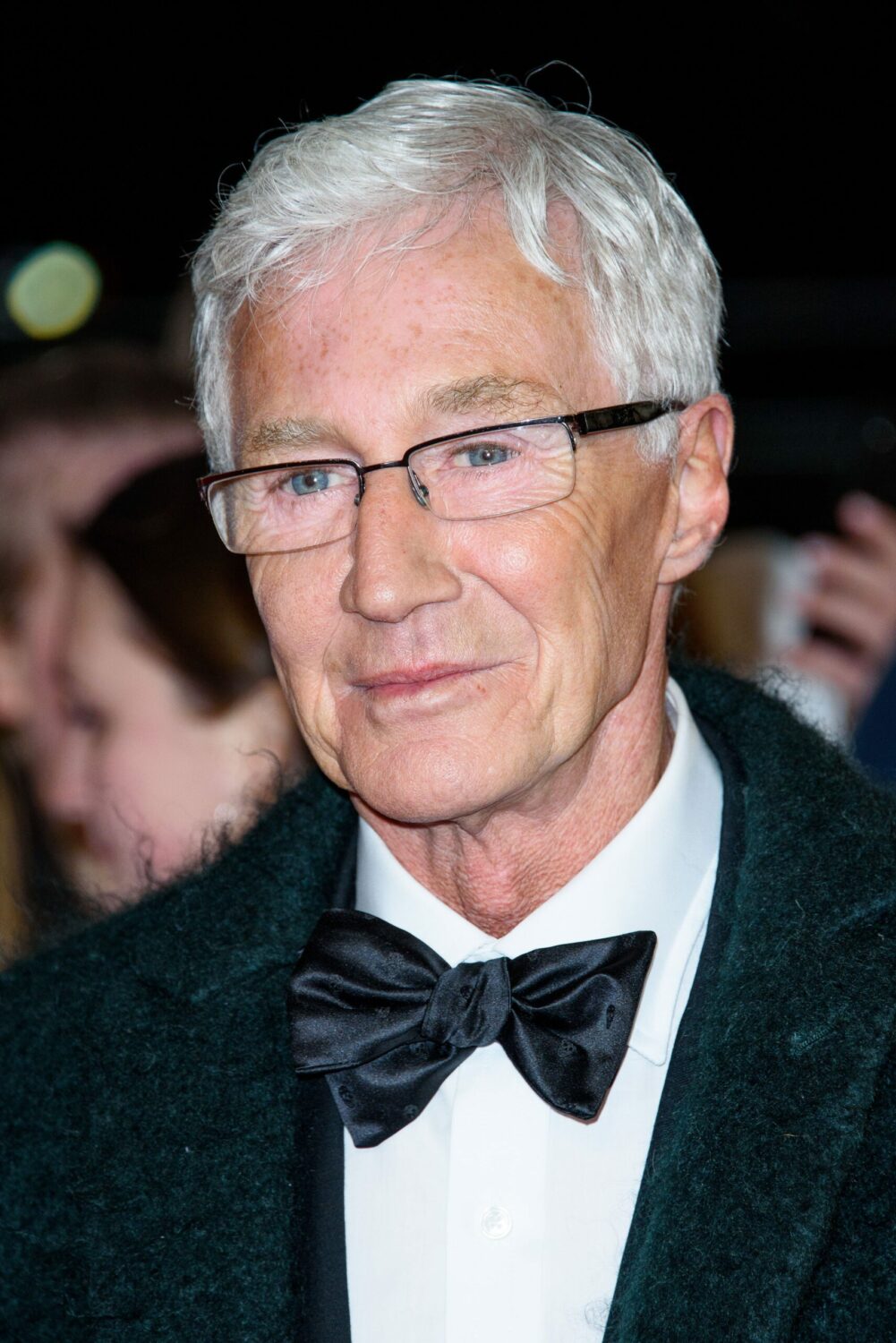 Paul O'Grady on the red carpet in a bowtie and warm coat