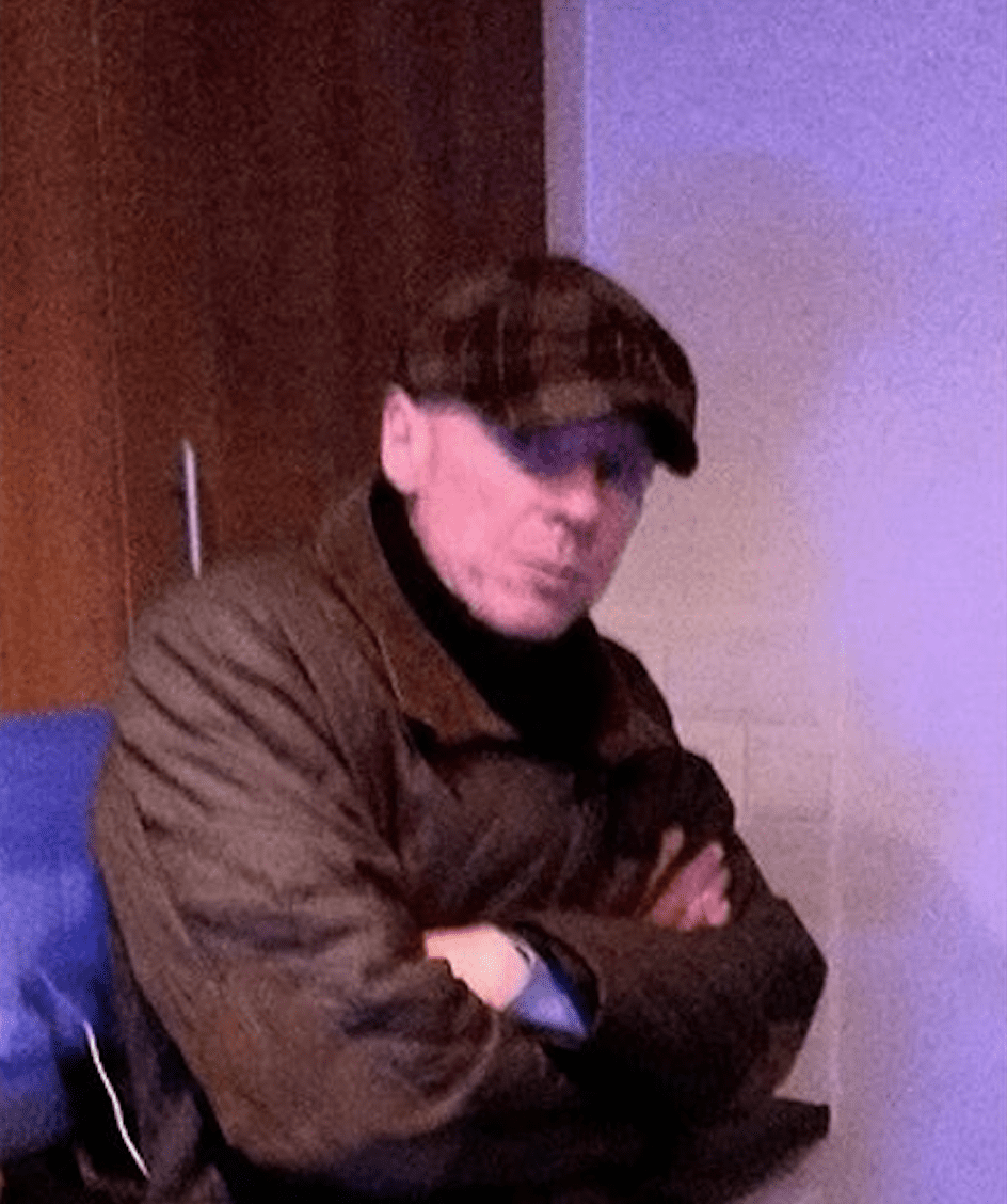 Jason Page wearing a cap and a coat with his arms folded