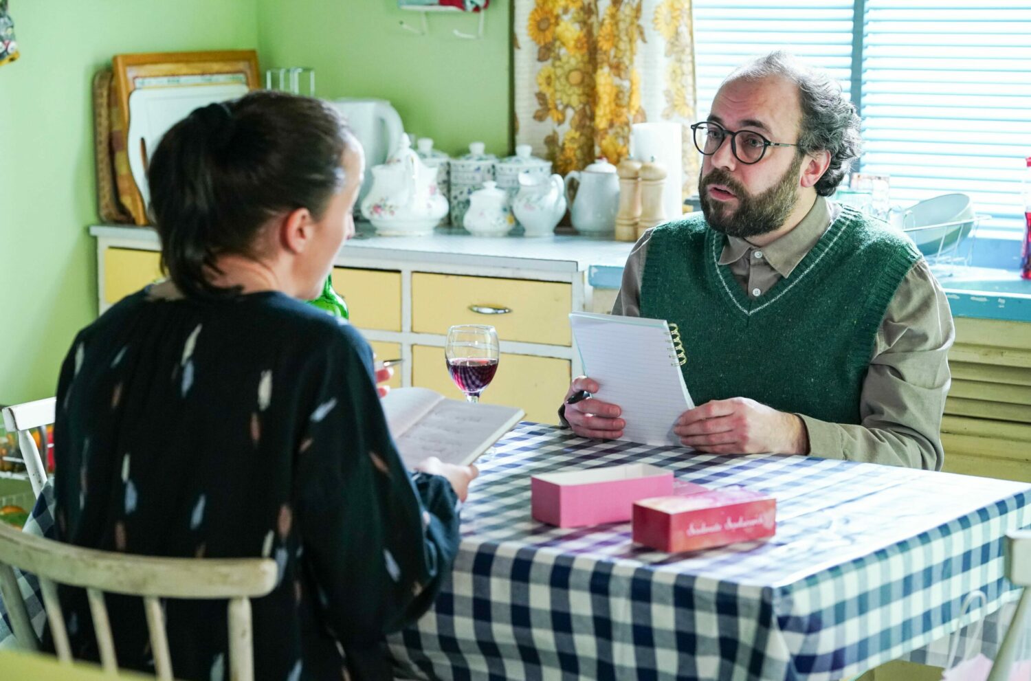 Sonia looks at Reiss as he looks up from his notepad in EastEnders