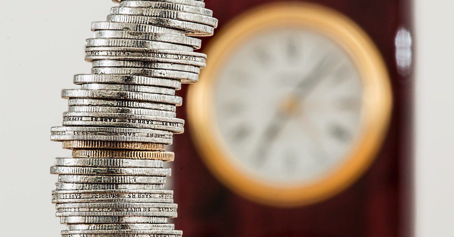 Collection of coins with a clock in the background