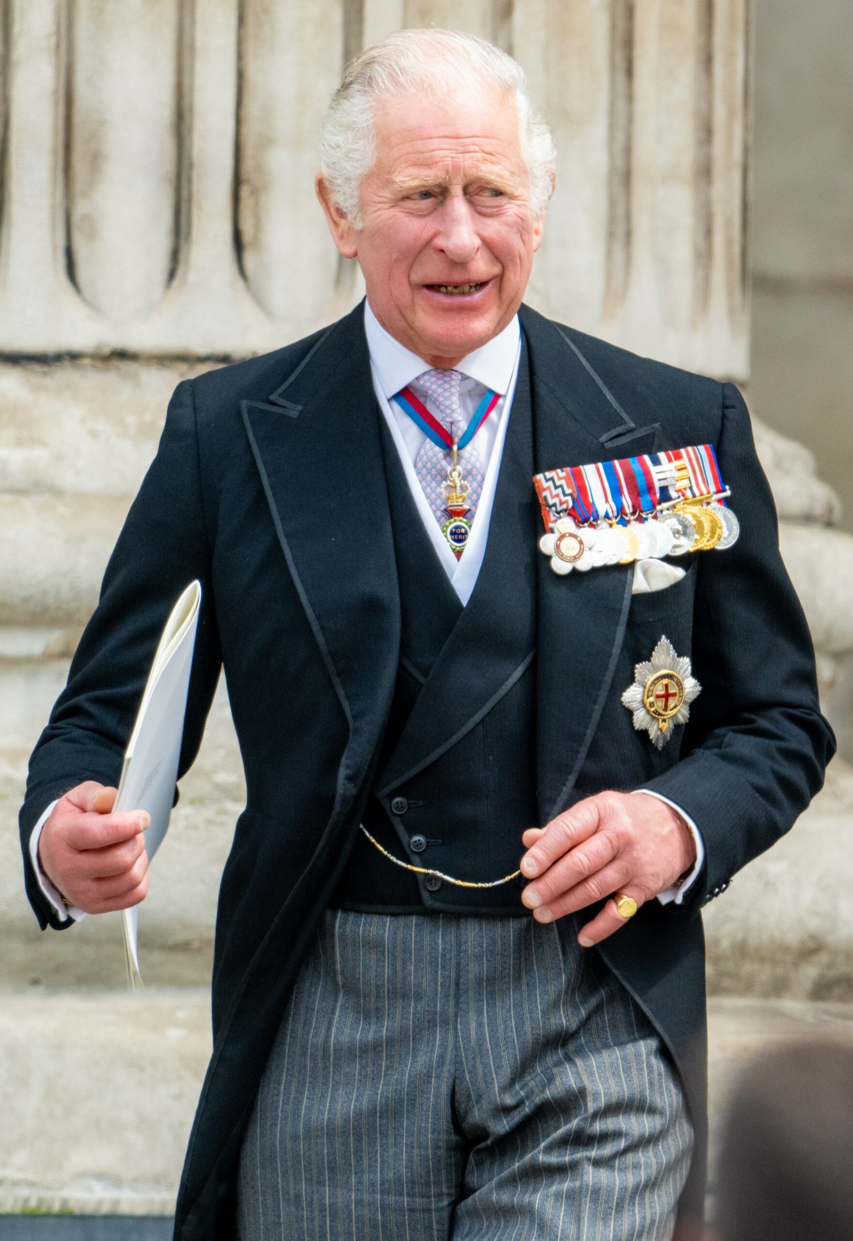 King Charles smiling in suit with medals at royal engagement