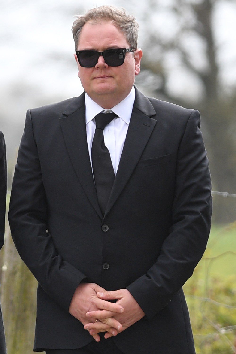 Alan Carr in black suit at Paul O'Grady funeral