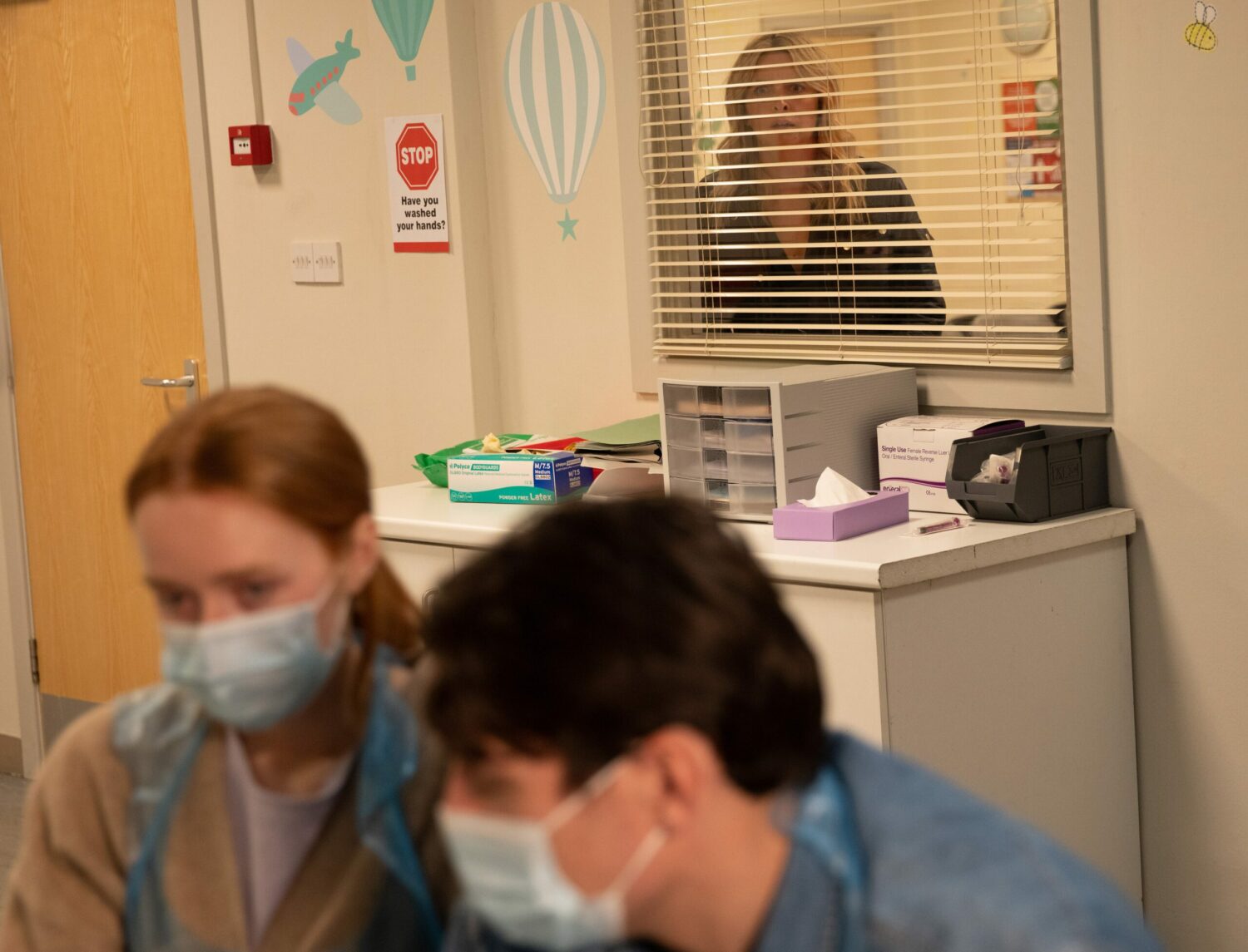Charity Dingle looks through the hospital room window crestfallen to see Chloe Harris and Mack Boyd together 