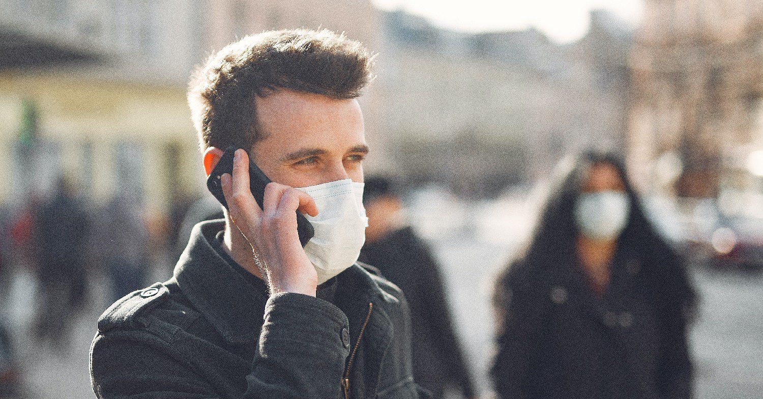 Man with a face mask on speaking on the phone 