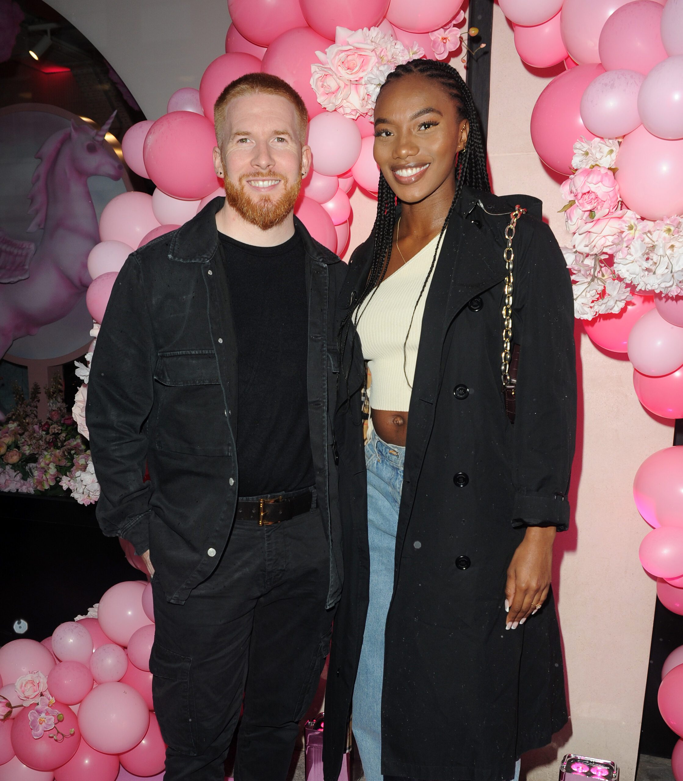 Neil Jones and Chyna Mills posing in front of pink balloons