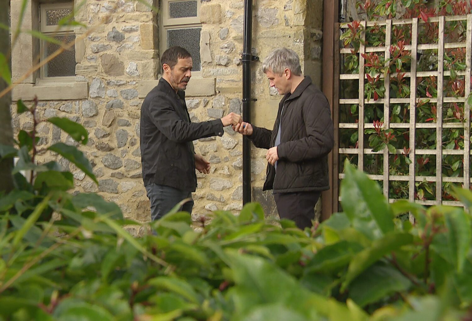 Caleb and associate Adrian make a deal outside on Emmerdale