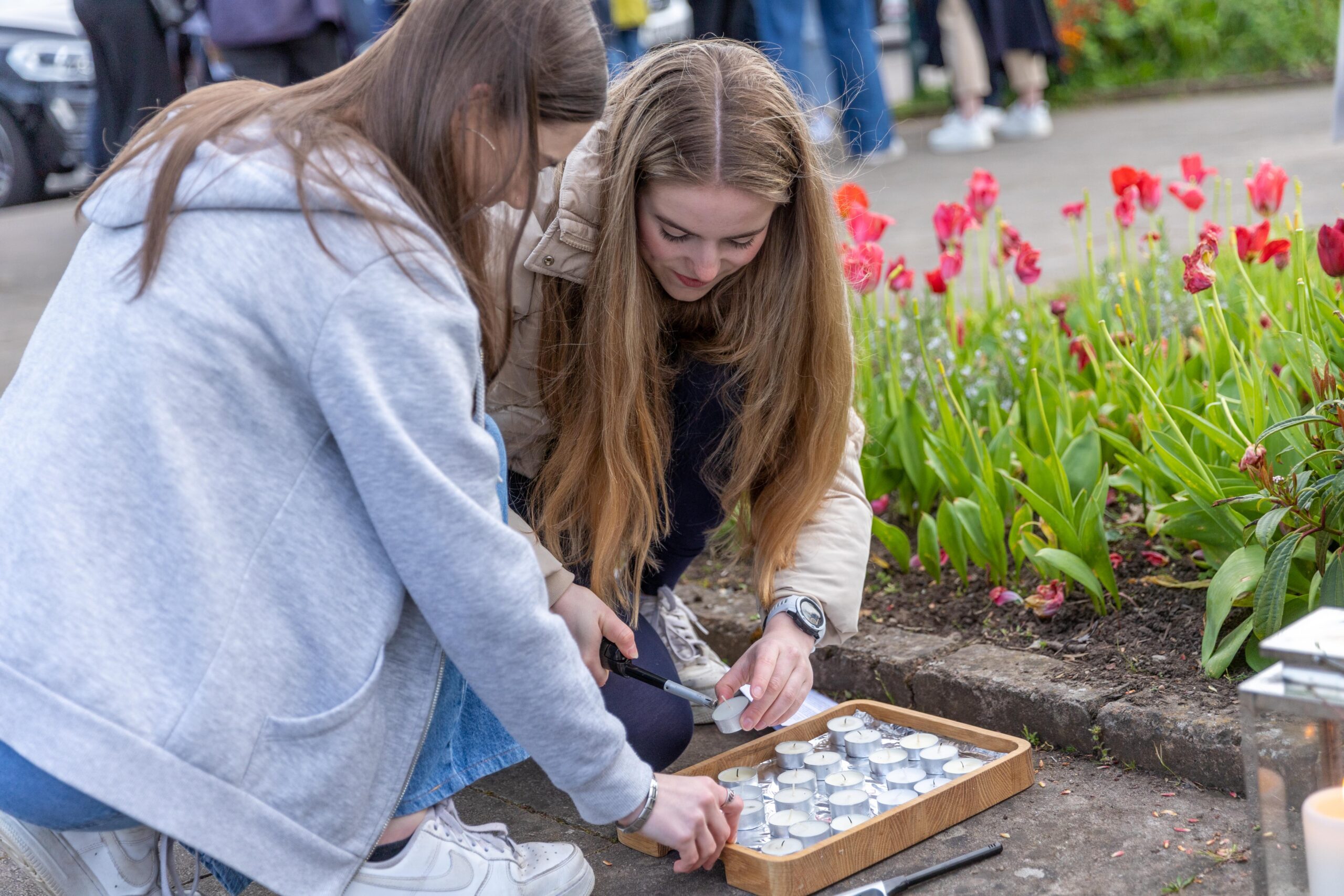 Amelie McCann and her friend lighting a candle for Madeleine