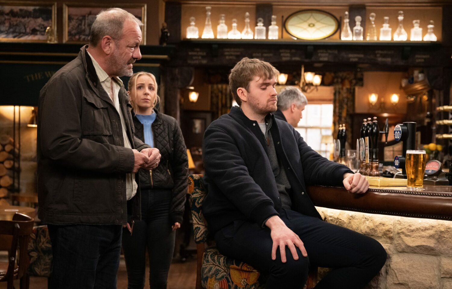 Jimmy tries to talk to Tom in The Woolpack as worried Belle watches on