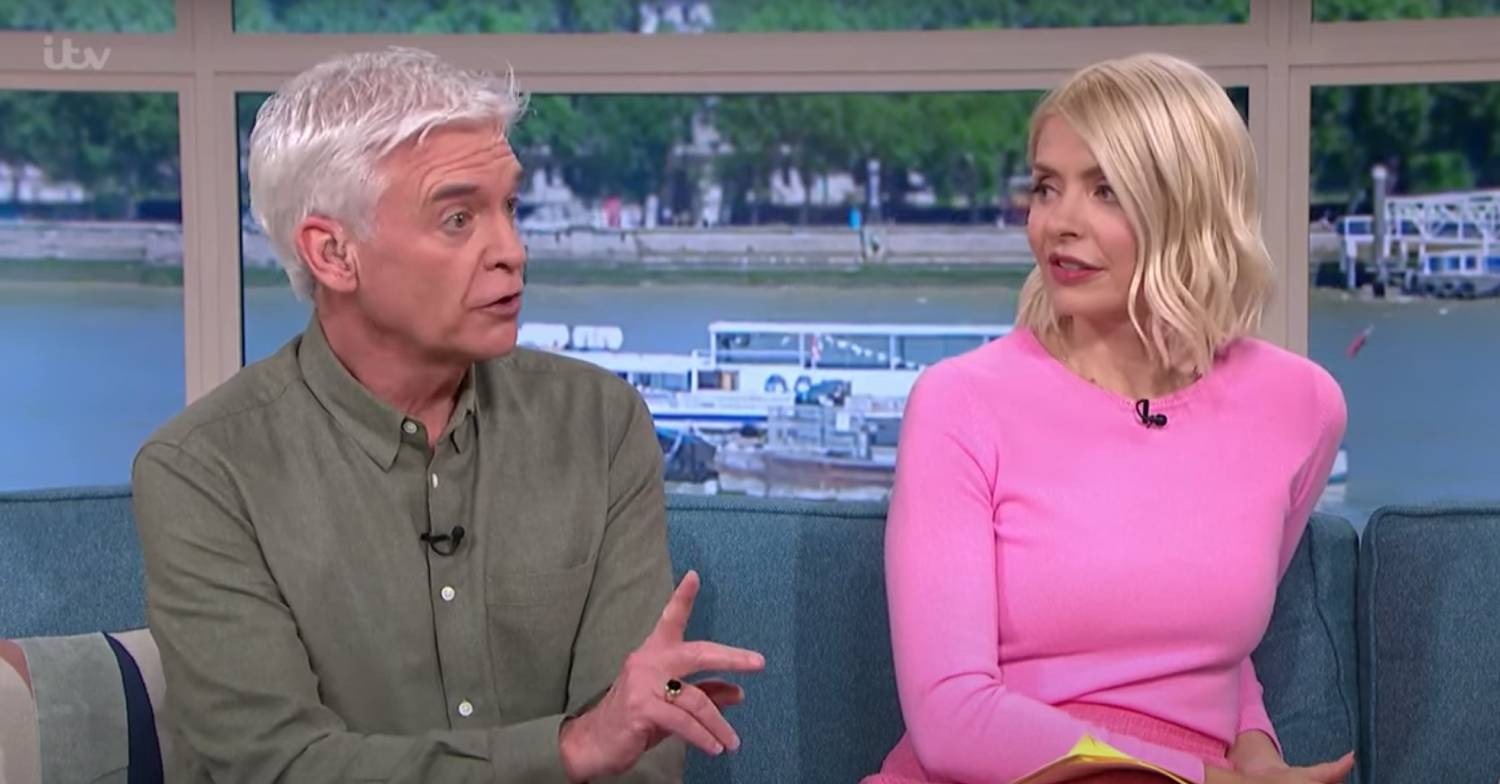 Phillip Schofield raises a finger as he sits next to Holly Willoughby on This Morning