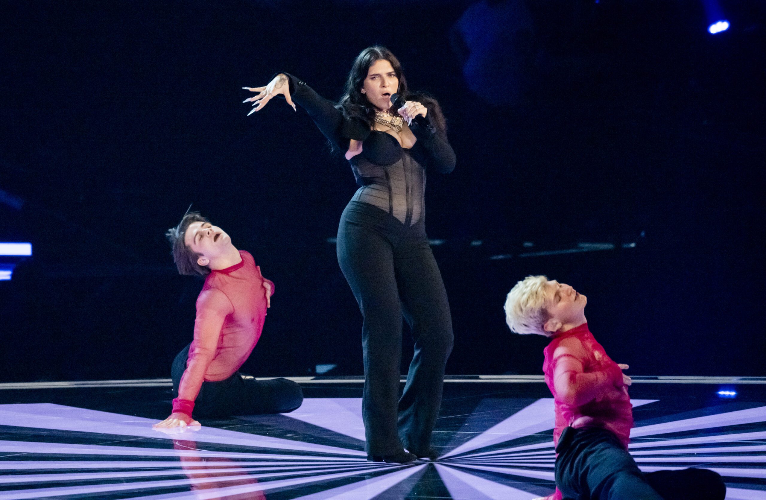 Mae Muller wearing all black on stage at Eurovision