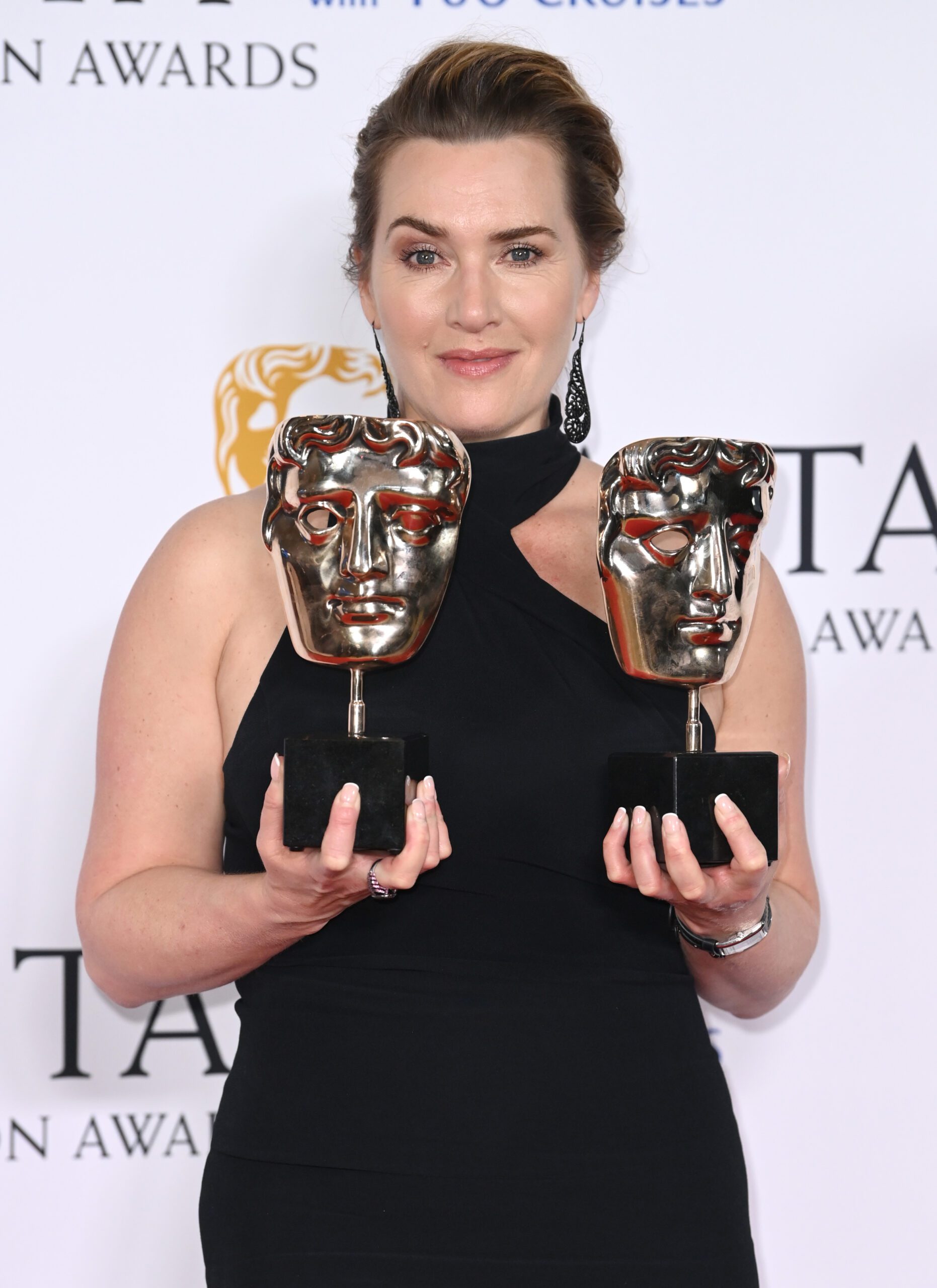 Kate Winslet holding her BAFTAs in 2023