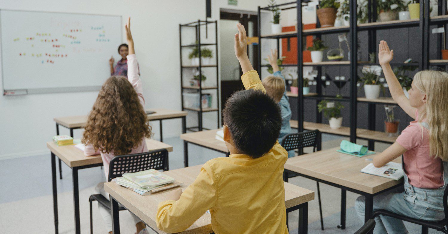 Children raising their hands in a classroom